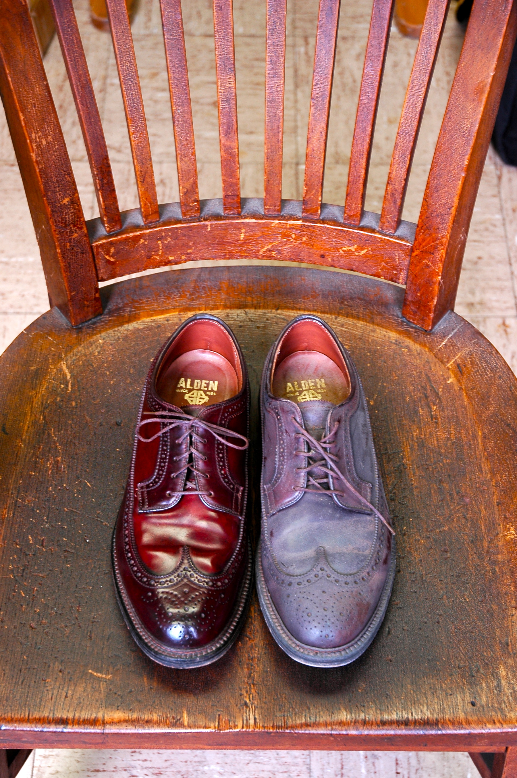 pair of Alden leather shoes on a wooden chair