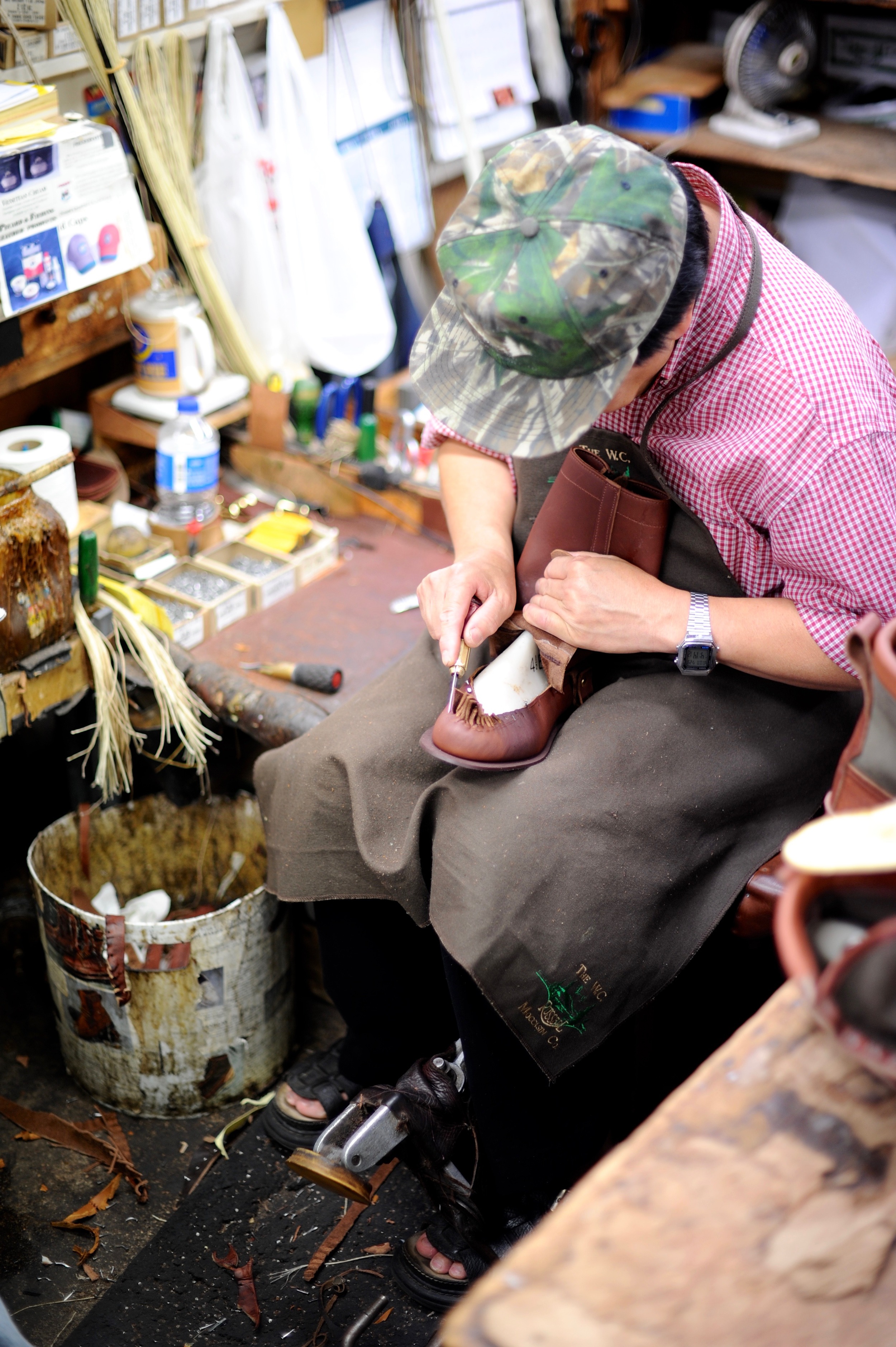 worker assembles leather shoe