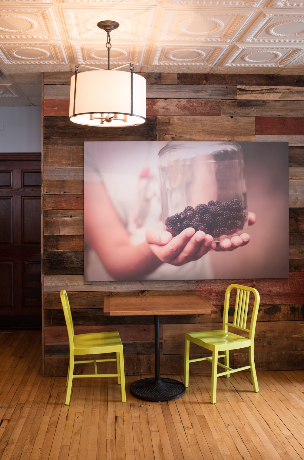 A barn wood wall design and tin ceiling tiles welcome market guests at this Glen Ellyn restaurant.