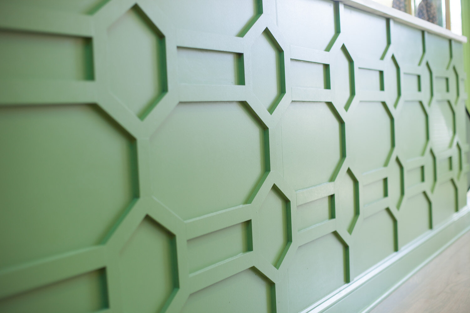 A unique restaurant service counter with custom trim in a hexagon pattern painted in Benjamin Moore Forest Hills Green (433). Design by Two Hands Interiors.
