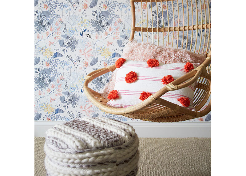 Serena and Lilly hanging chair, footstool from Home Goods, and pillow by Target, all surrounded by the Anthropologie Rose Petals Wallpaper. Design by Two Hands Interiors.