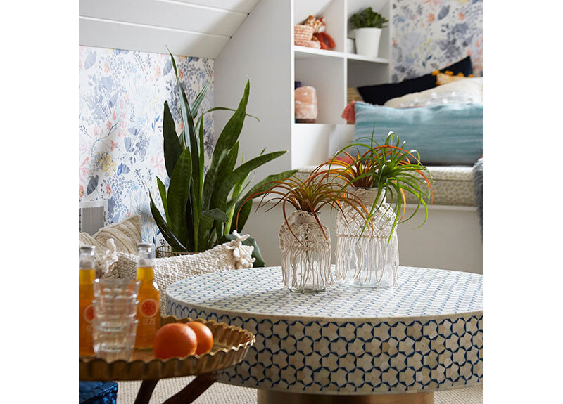 The boho vibe of this teen hangout destination is complete with the Anthropologie table, Anthropologie Rose Petals Wallpaper, and custom storage. Design by Two Hands Interiors.