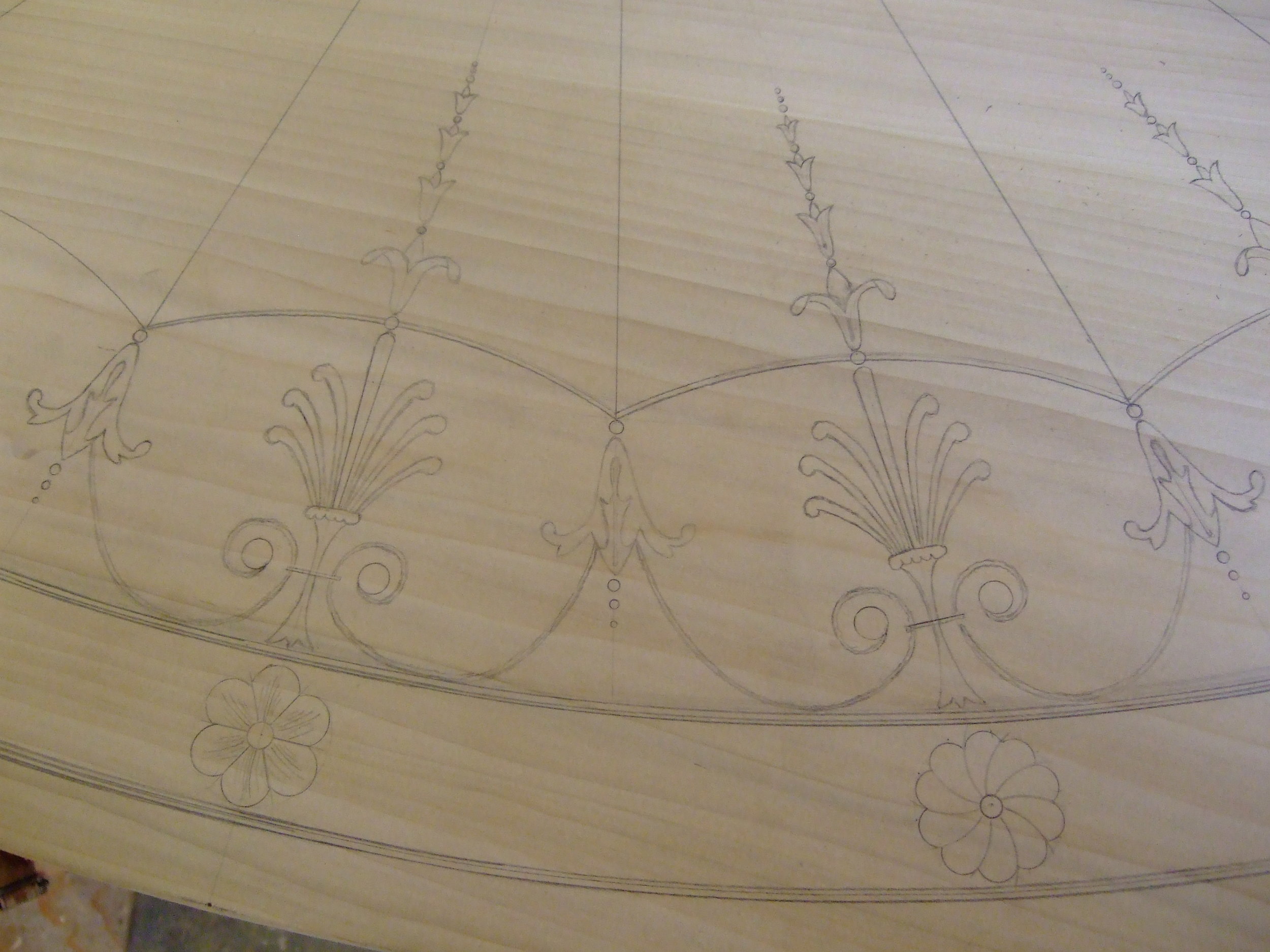 Freehand drawing of perimeter inlay details on the poplar pattern of the top.
