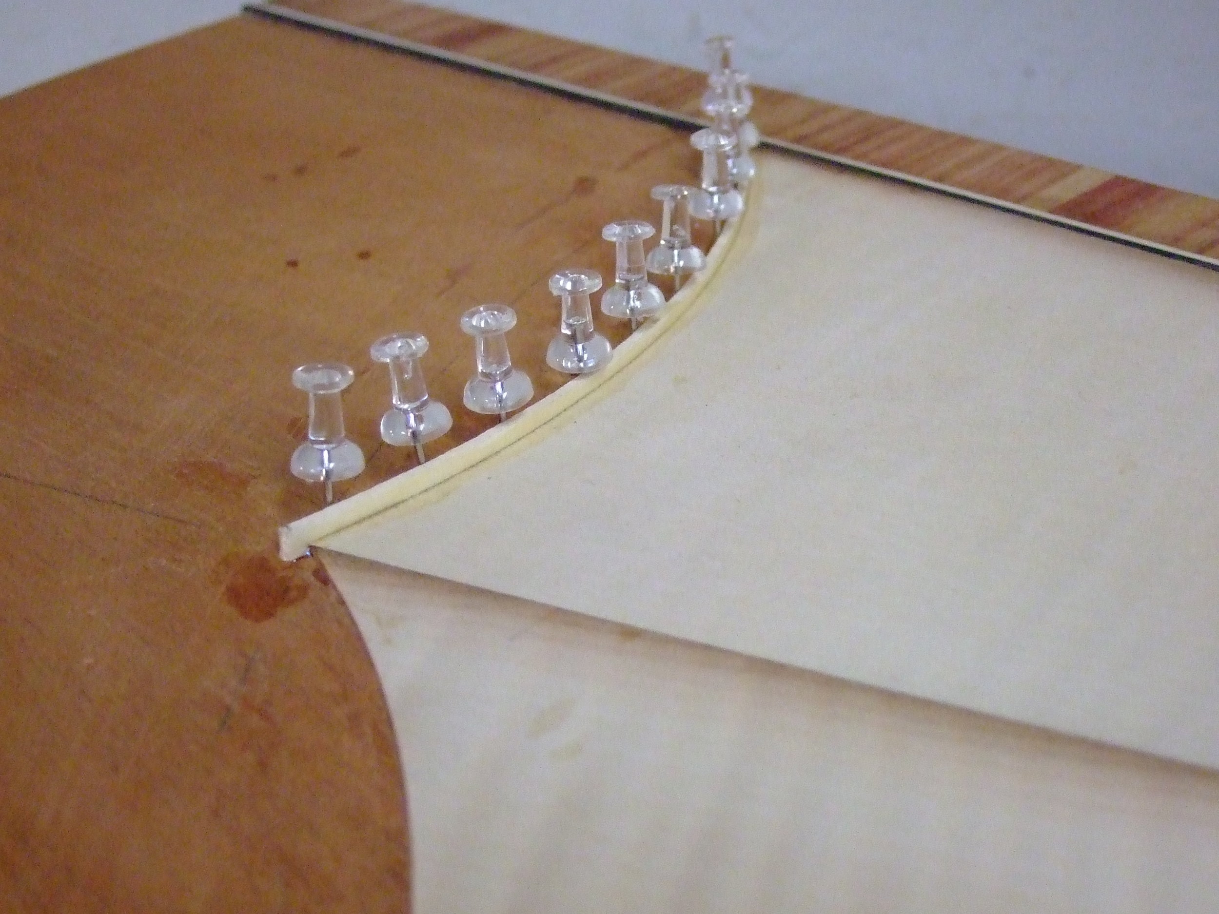 Glueing and clamping holly strings to the edge of the sycamore fan. I made all the strings from solid holly boards because the original strings were thicker than modern veneer.