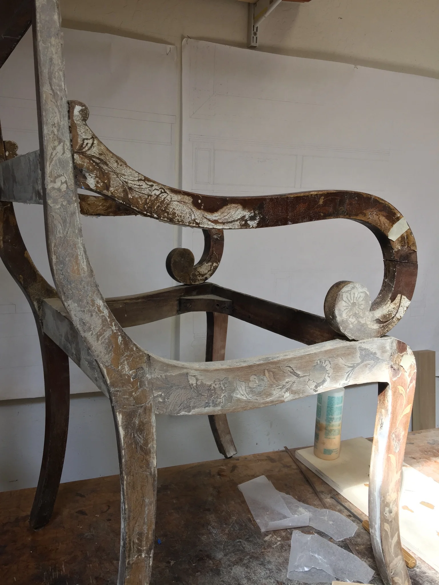 Damaged armchair with the side of the front leg mostly patched. 