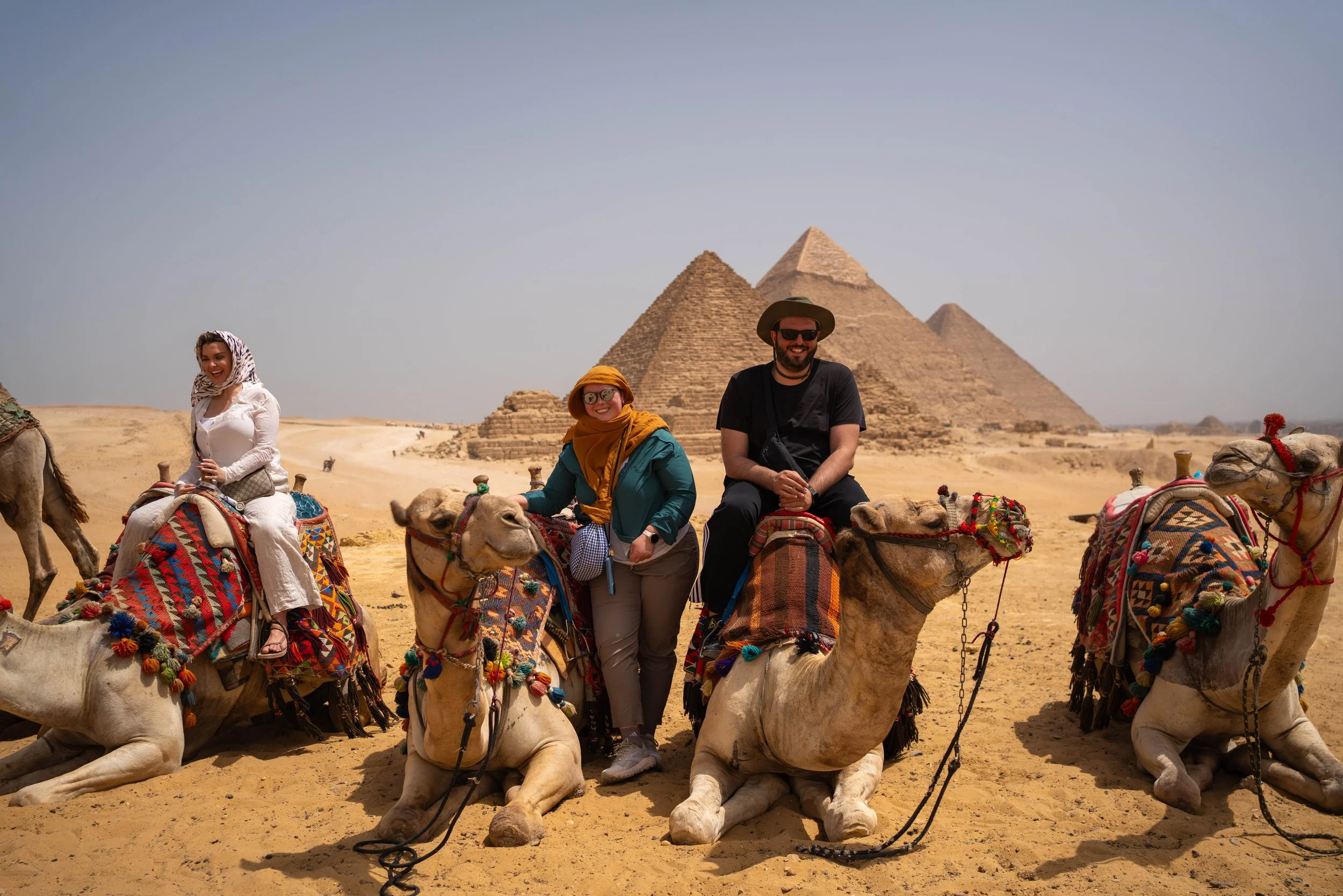Starlight Voyages guests enjoying their iconic camel ride around the pyramids of Egypt! Book your dream Egypt vacation today.
