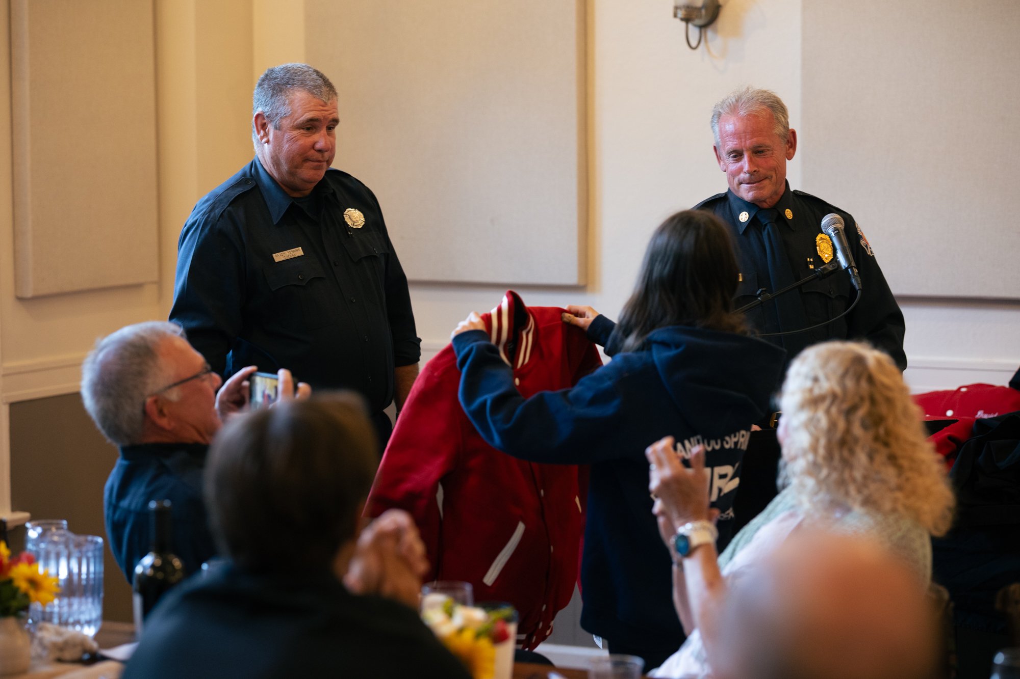  James Crowl’s daughter accepts a commemorative red jacket on her father’s behalf. 