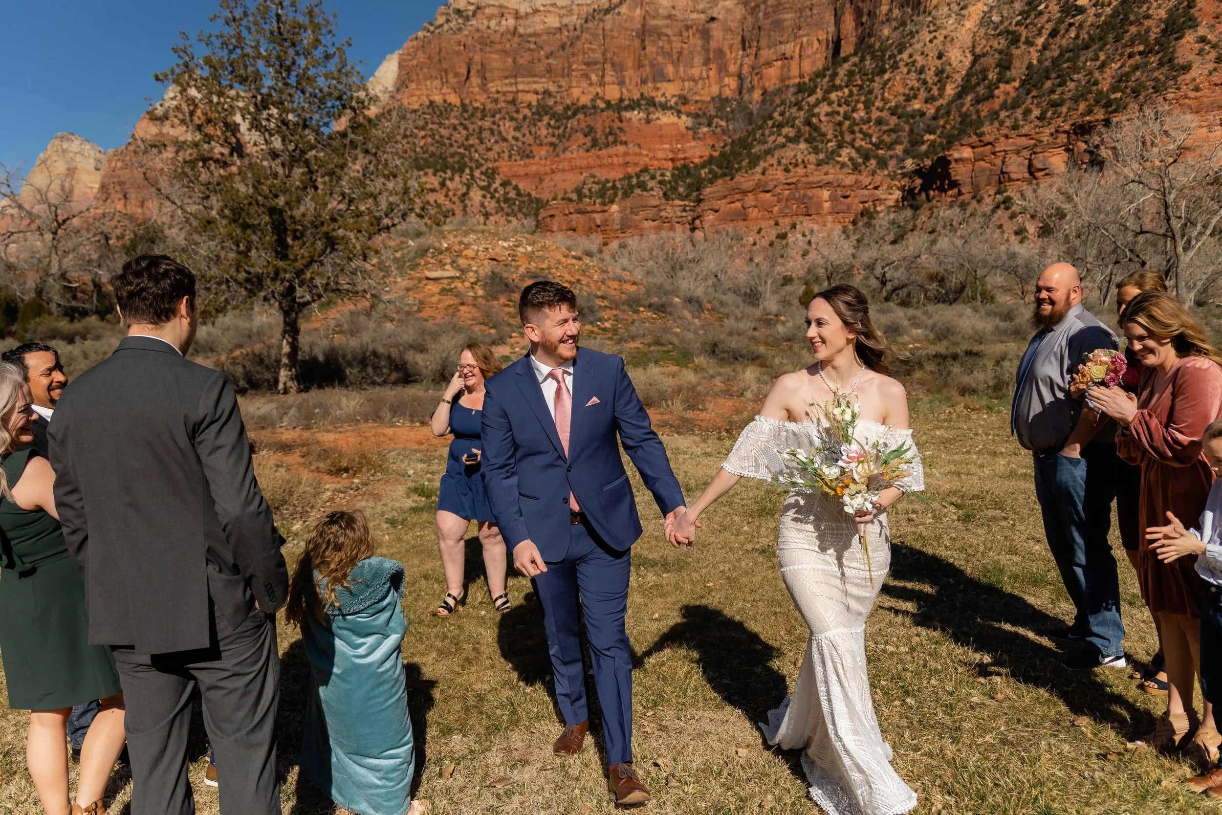 bride and groom walk together out of ceremony at nature center in zion