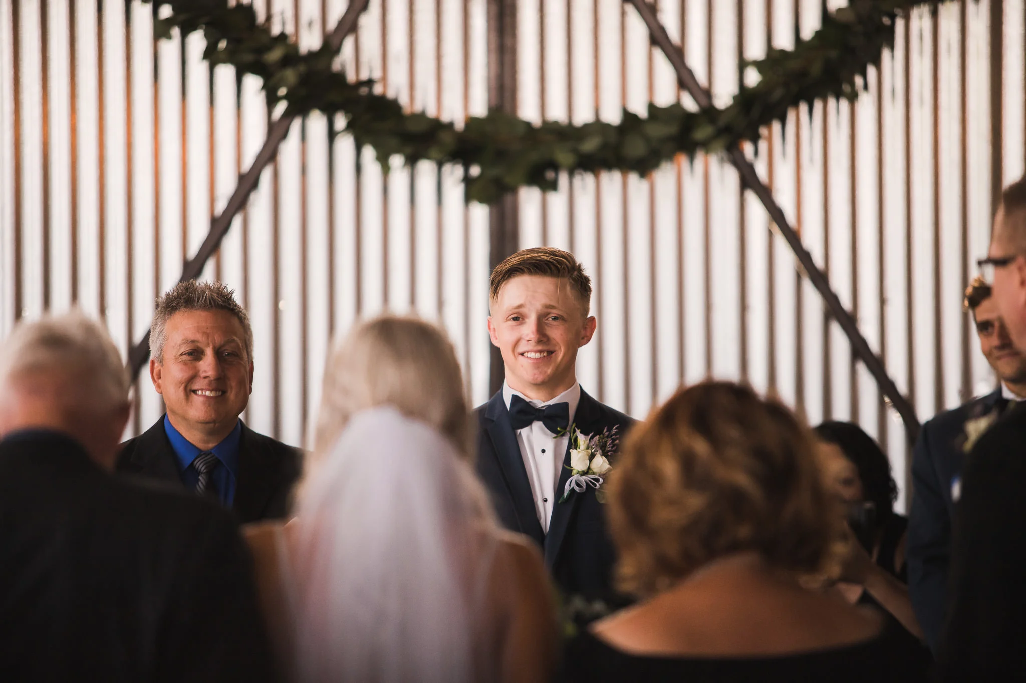Groom looking at bride as she walks down the isle
