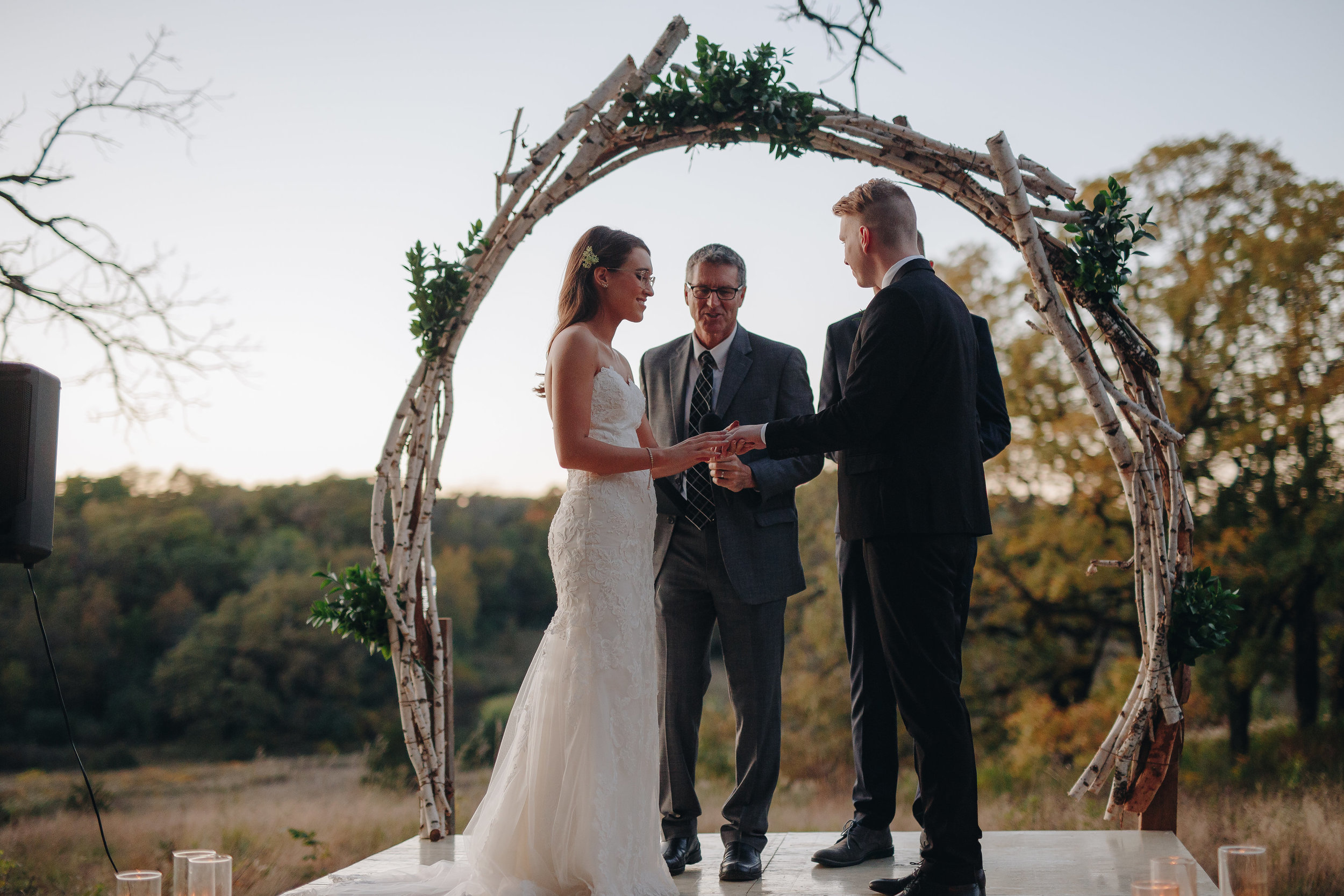 Bride putting ring on groom during wedding ceremony