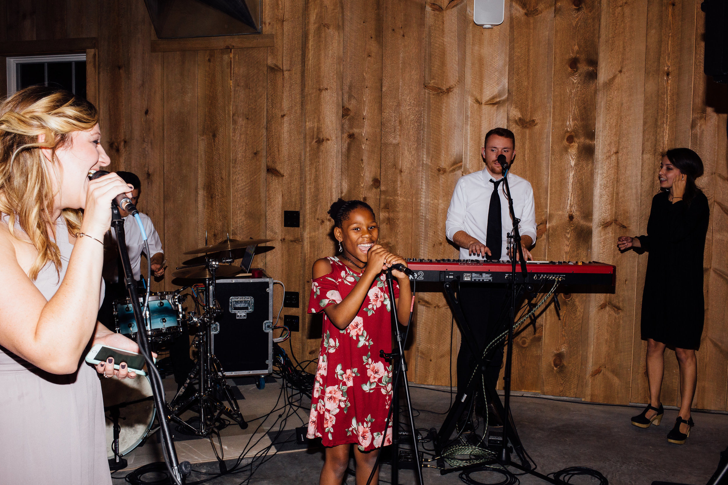 Mother and daughter sing with live band for the bride and groom at wedding reception Almquist Farm Minnesota