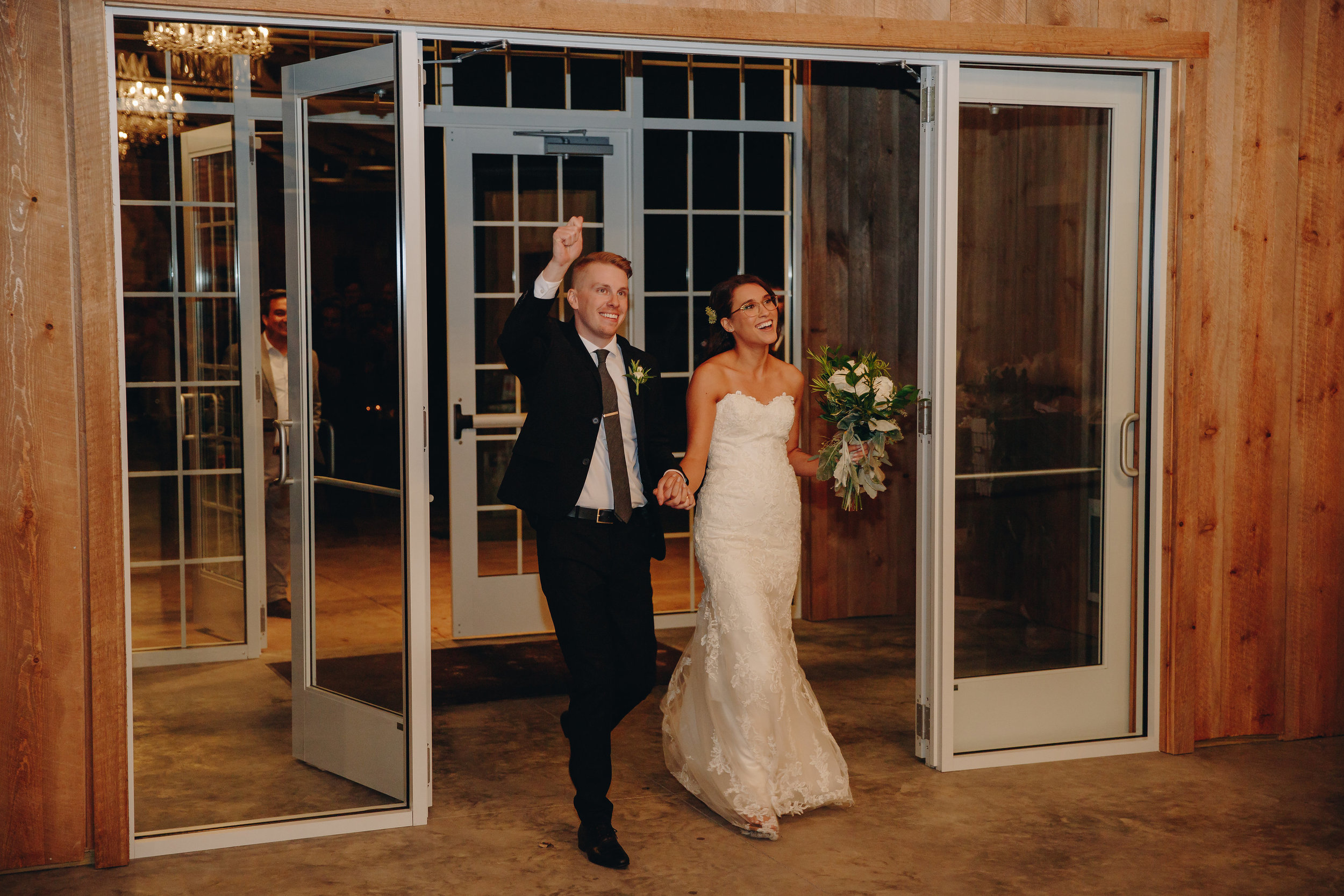 Bride and Groom entrance into modern barnhouse reception at their wedding