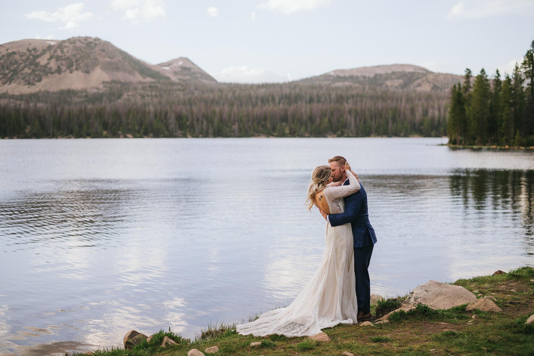 Couple kiss for wedding photos at Mirror Lake in the Utah Uinta Mountains