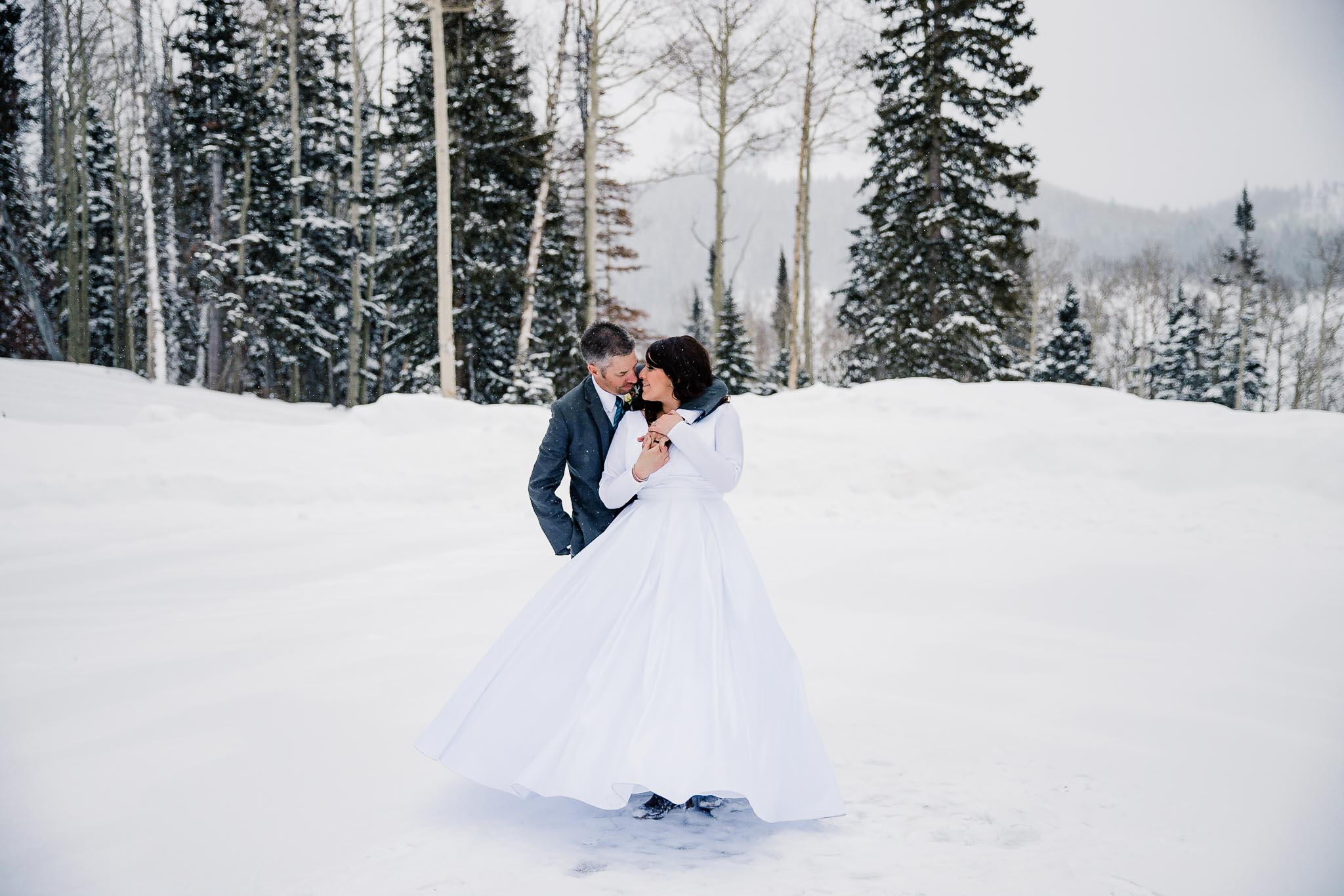 Couple dances in snow at winter wedding at Eagle Mountain Resort, Utah