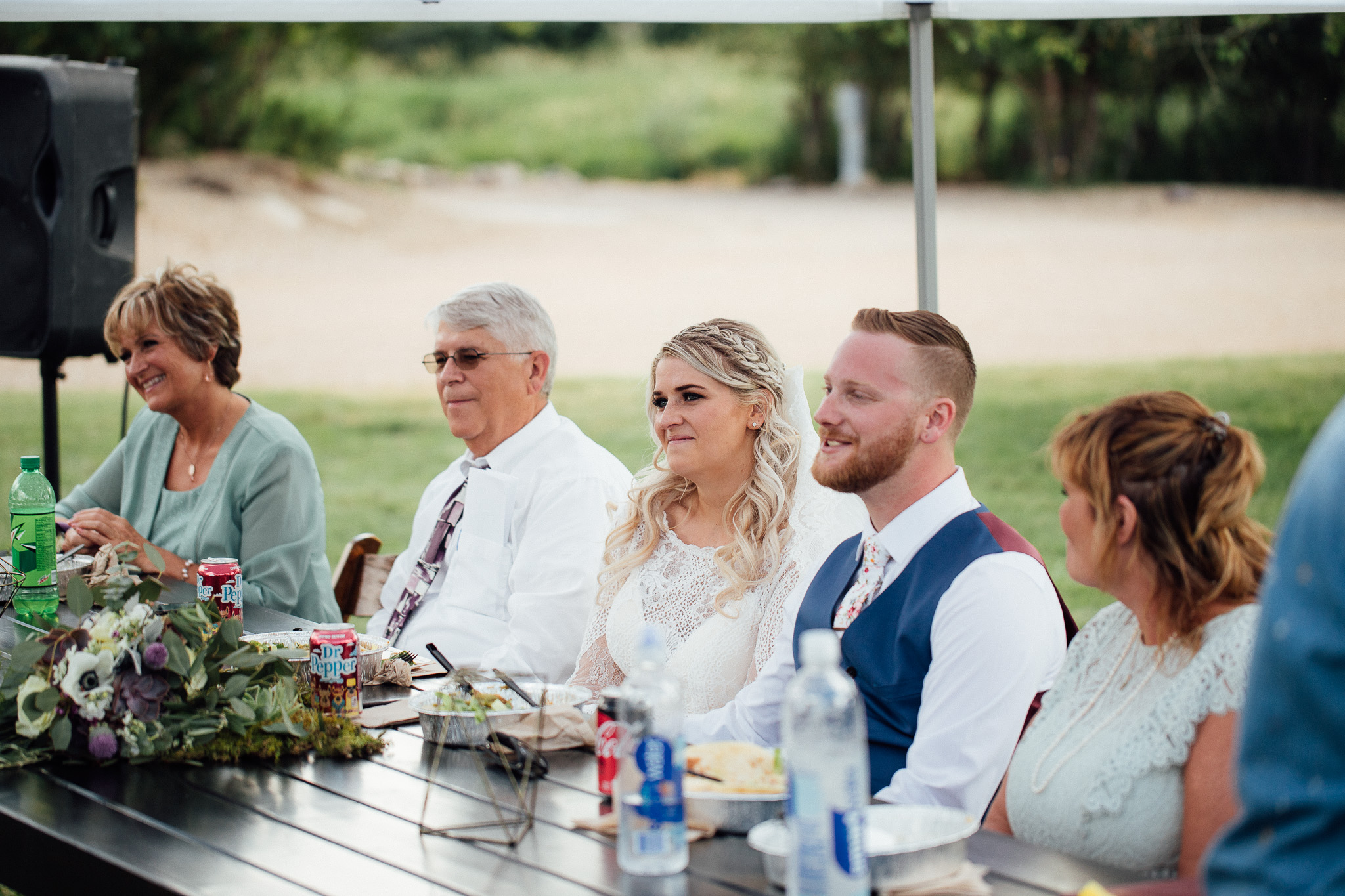 Bride and groom listen to toasts during wedding dinner