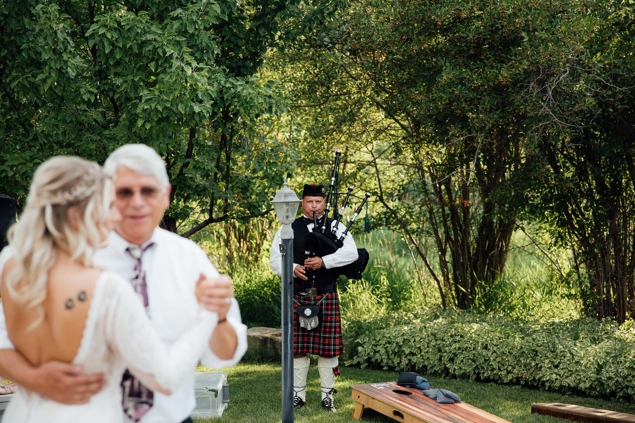 Bride dances with her father to bagpipes during wedding reception