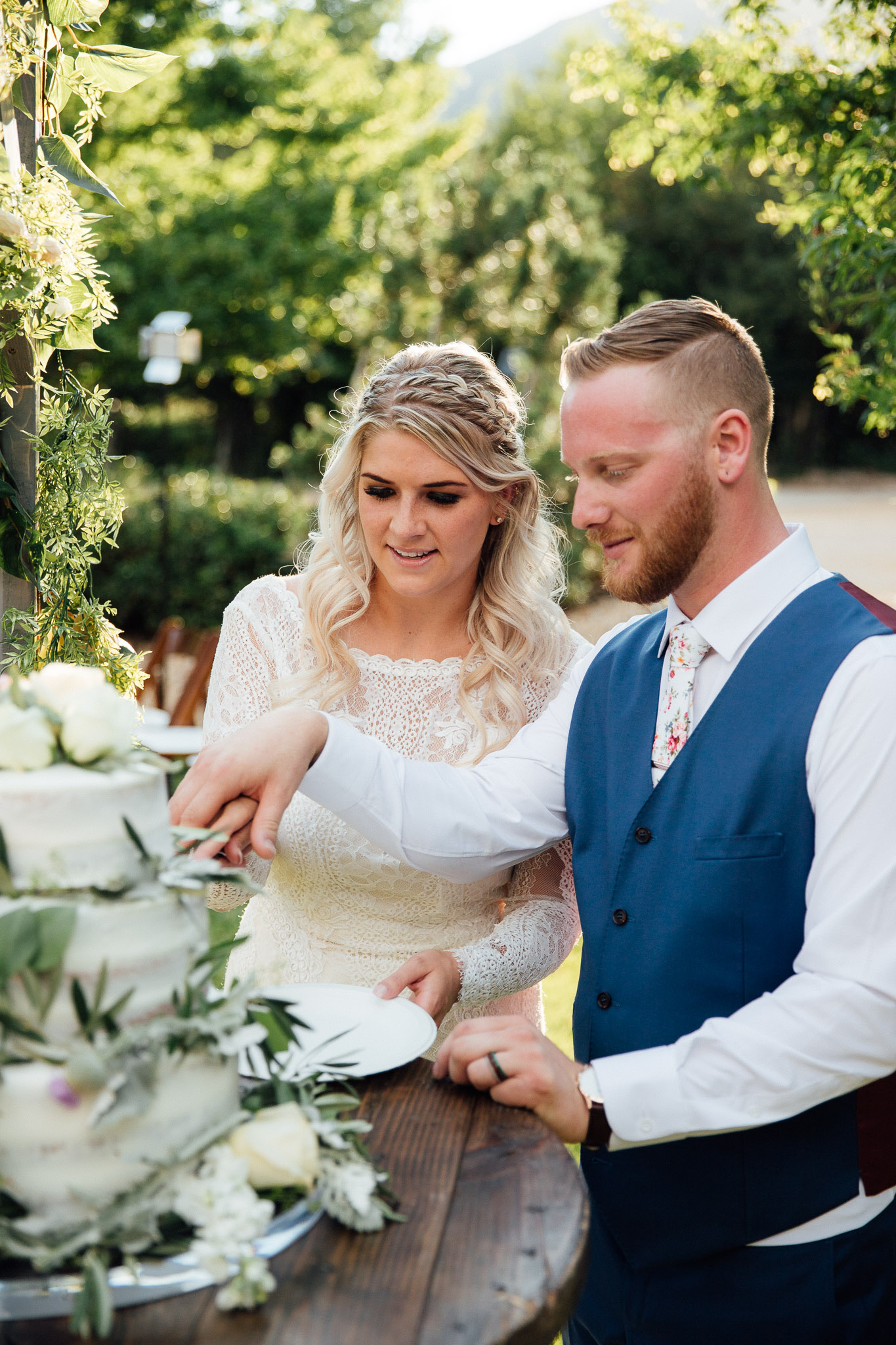 Bride and groom cut cake at wedding reception
