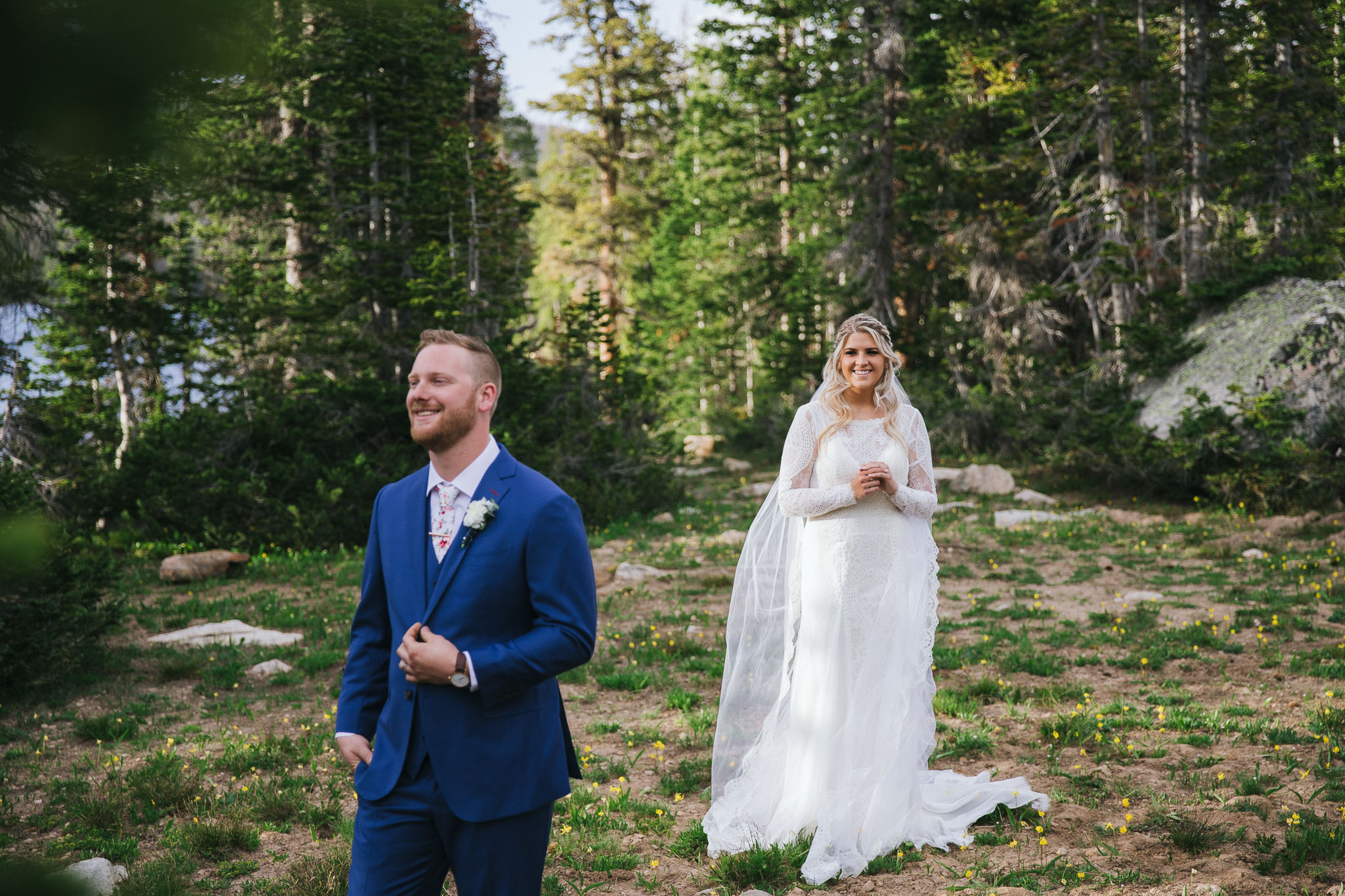 Bride and Groom poses for wedding photos at Mirror Lake in the Utah Mountains