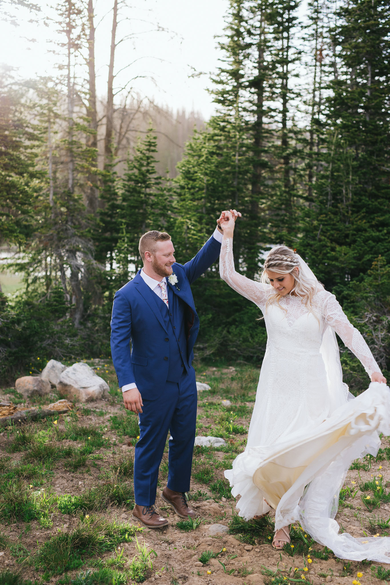 Bride and Groom poses for wedding photos at Mirror Lake in the Utah Mountains