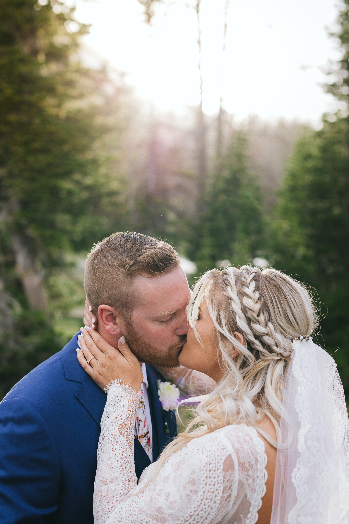 Bride and Groom poses for wedding photos at Mirror Lake in the Utah Mountains