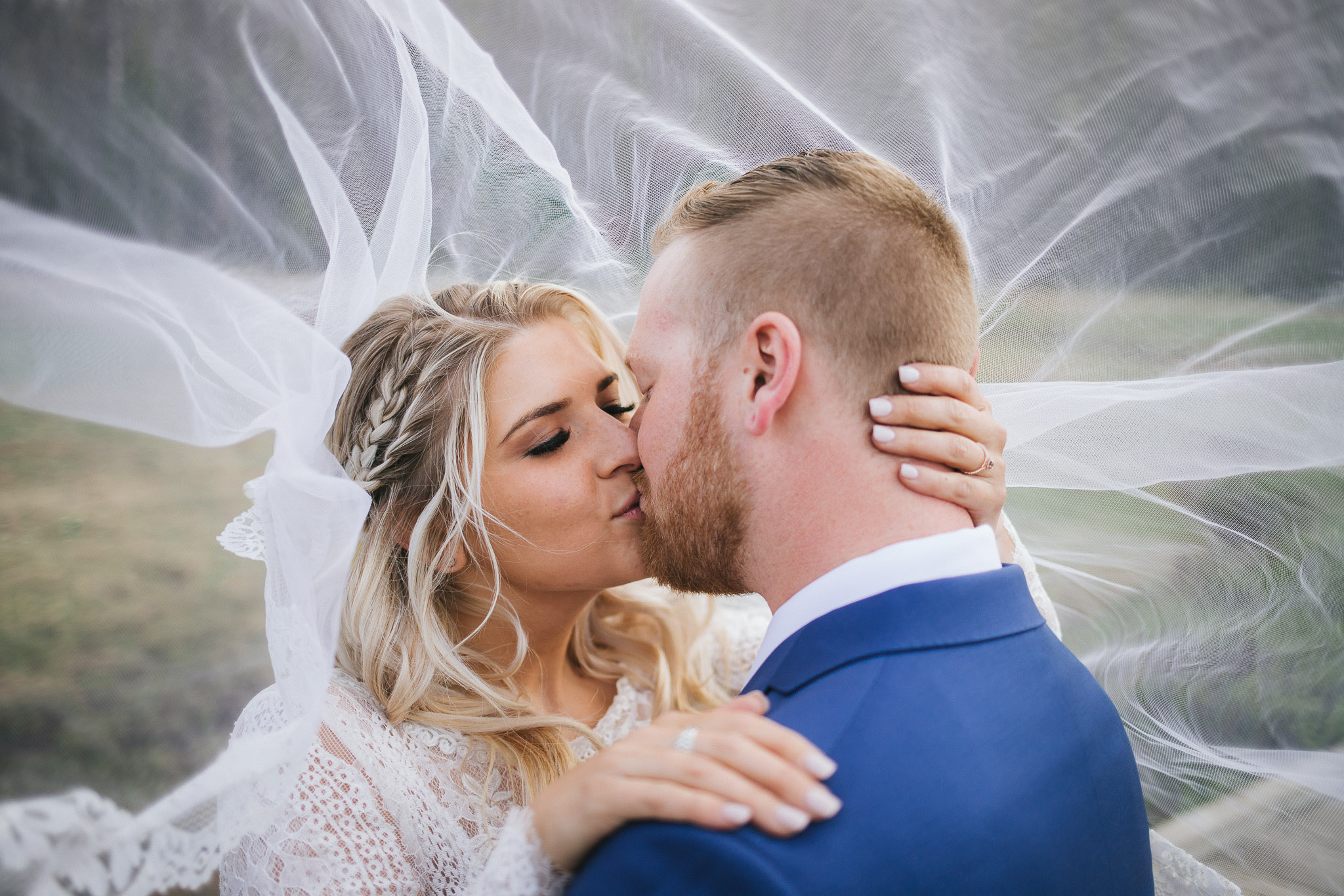 Bride and Groom pose for wedding photos at Mirror Lake in the Utah Mountains