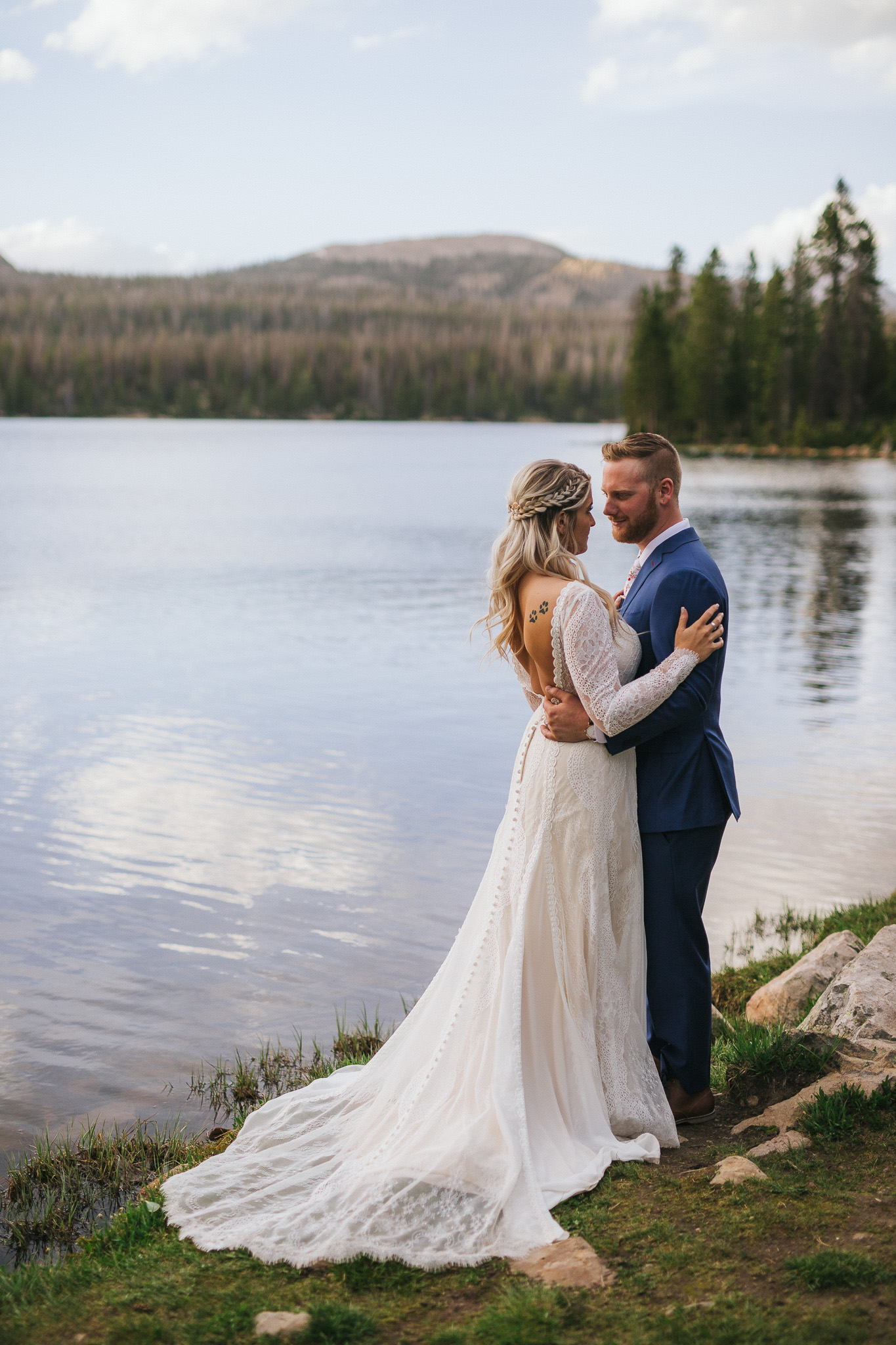 Bride and Groom pose for wedding photos at Mirror Lake in the Utah Mountains