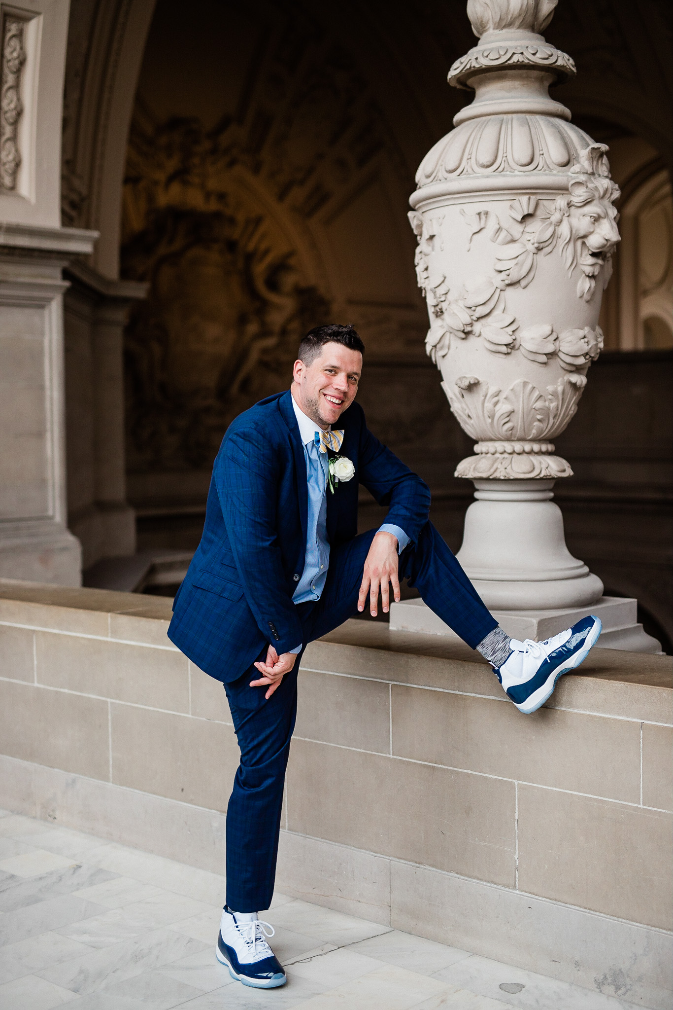 Groom poses for wedding portraits in San Francisco City Hall