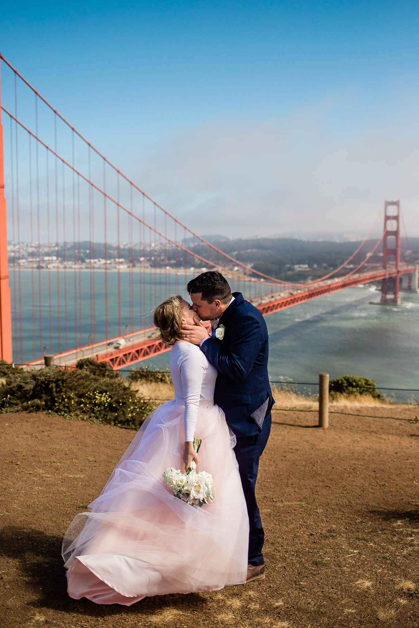 Bride and Groom pose for wedding photos near the Golden gate bridge