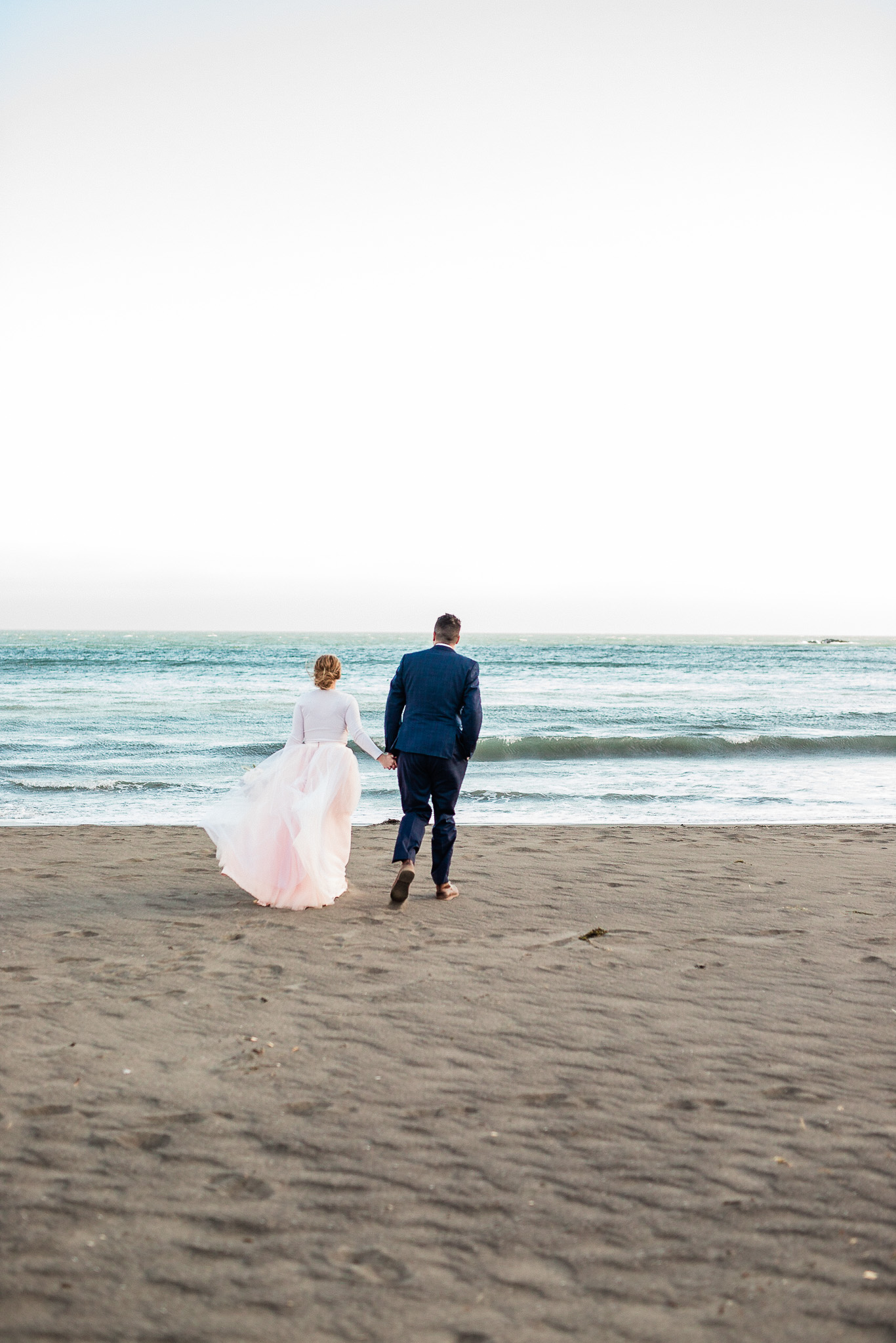 Bride and Groom pose for wedding photos on the beach near San Francisco