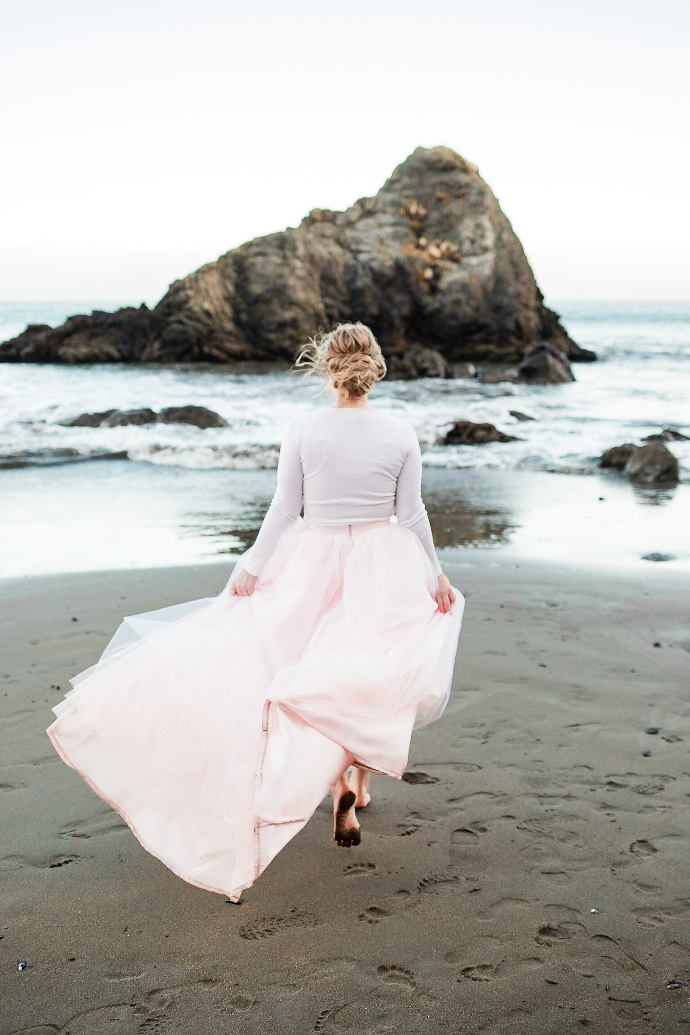 Bride poses for wedding photos on the beach near San Francisco