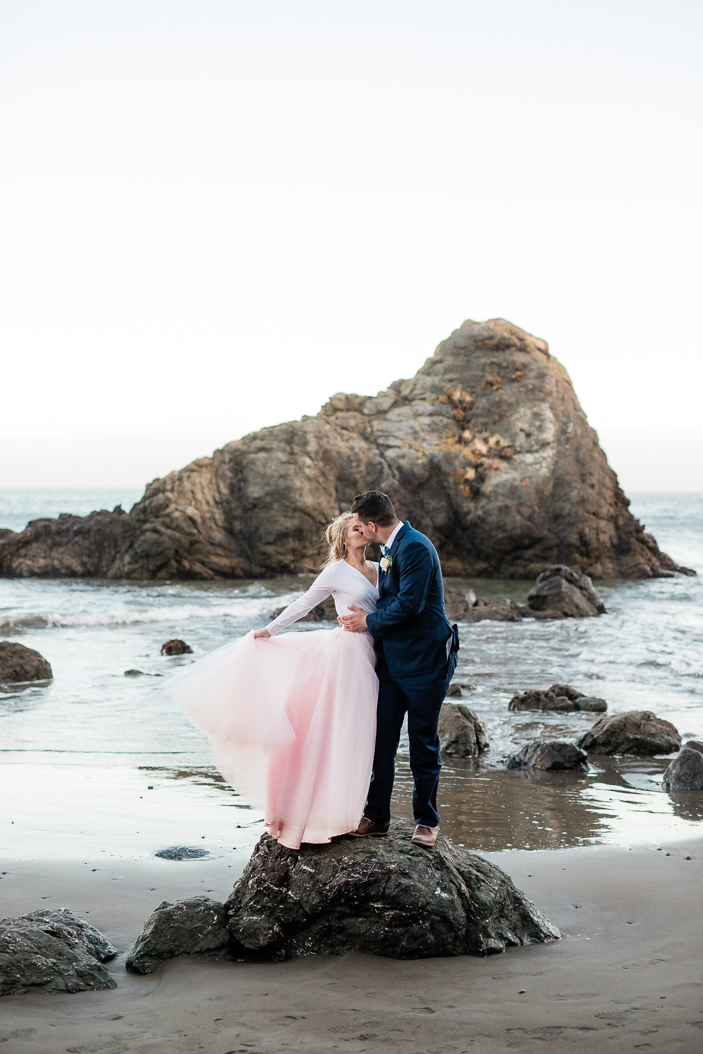 Bride and Groom pose for wedding photos on the beach near San Francisco