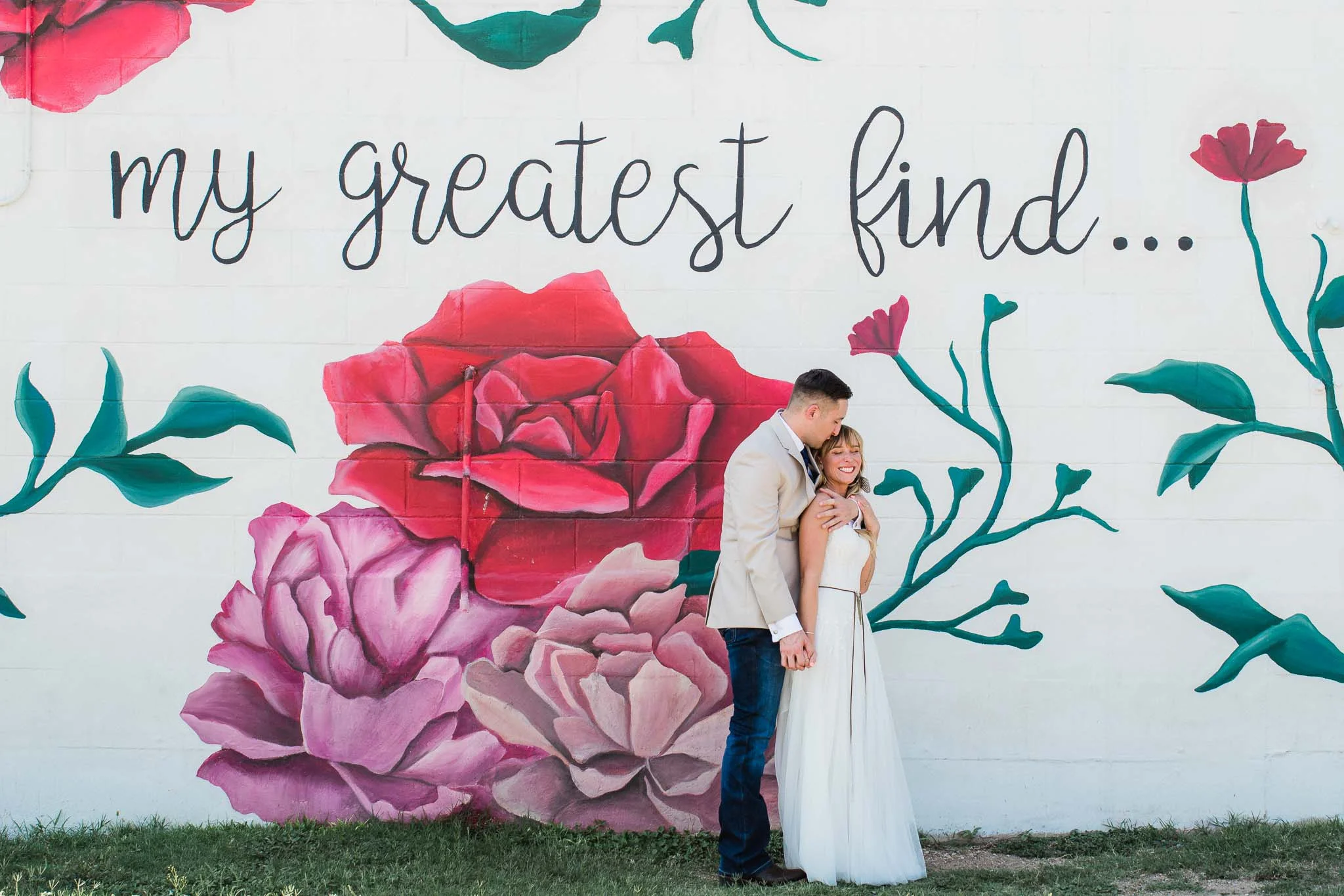 Wedding couple stand in front of My Greatest Find mural in Waco Texas