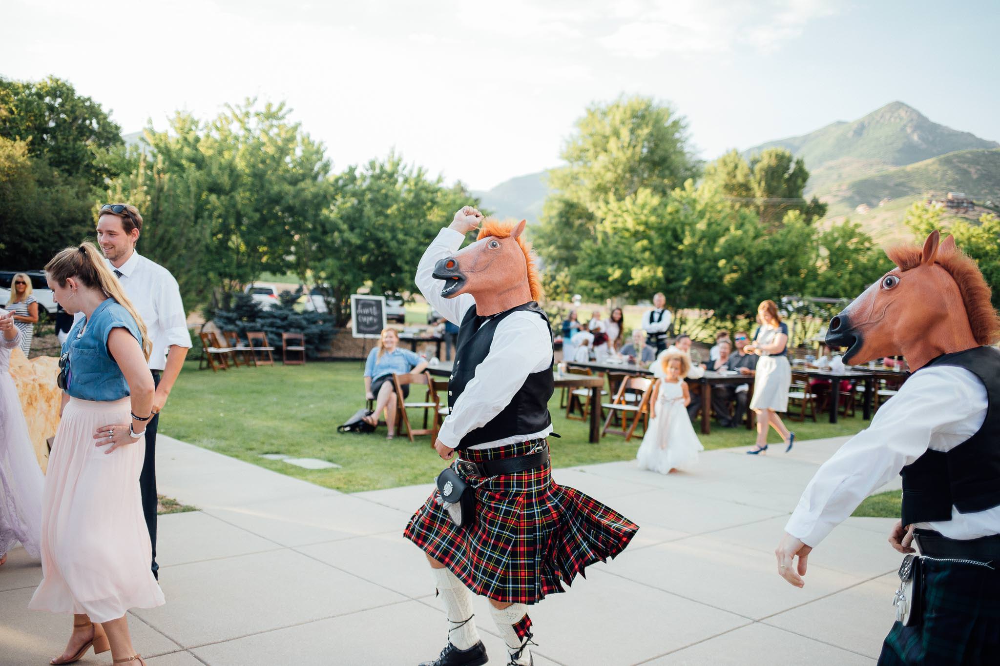Guest in Scottish kilt and horse head mask dances to Gangnam Style at Midway Utah mountain wedding reception