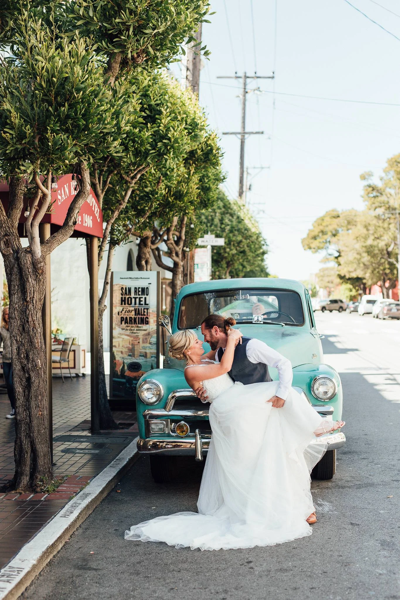Groom dips bride in front old truck by the San Remo Hotel in San Francisco Elopement
