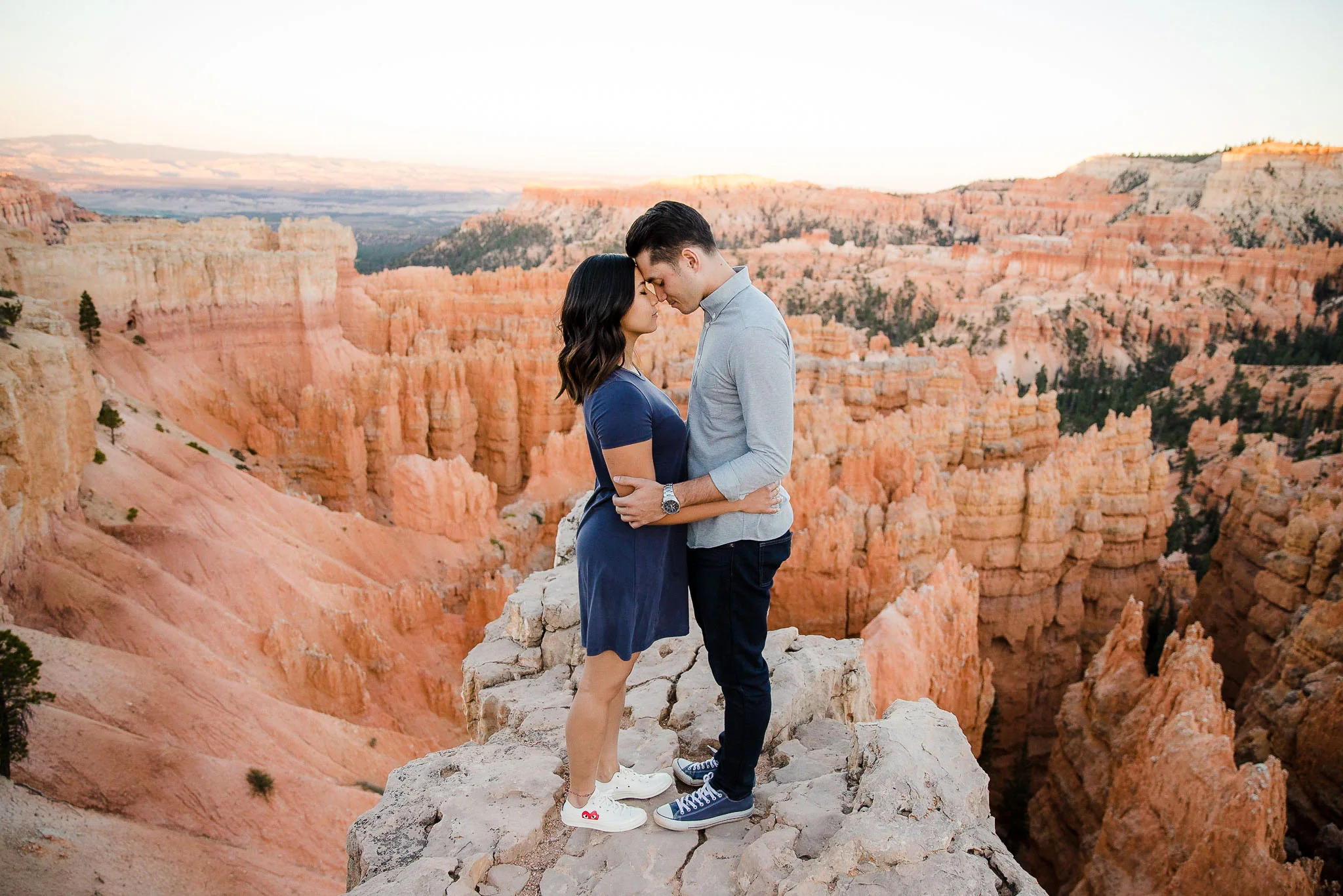 Couple stand together with Bryce Canyon hoodoos behind them for their adventure engagement session in Utah