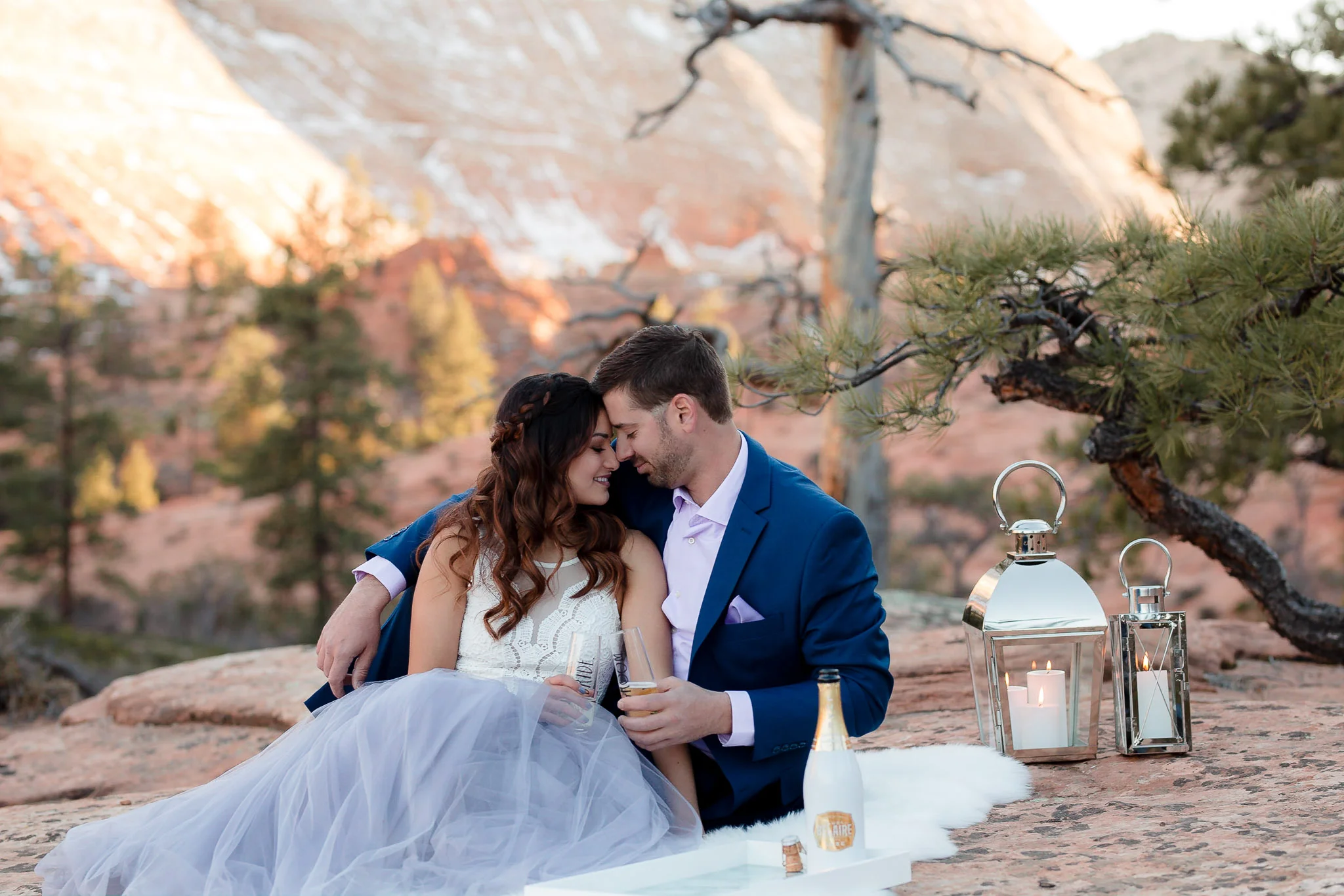 Couple snuggle on a blanket during their adventure engagement session in Zion National Park Utah
