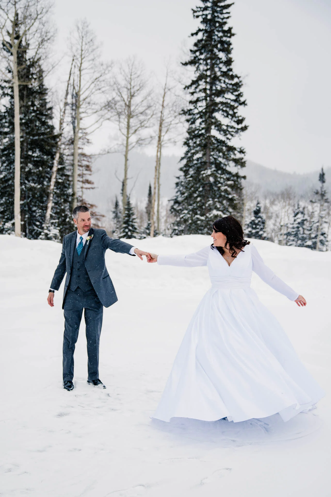 Bride and groom dance in the snow Utah mountain wedding photographer Eagle Point Resort