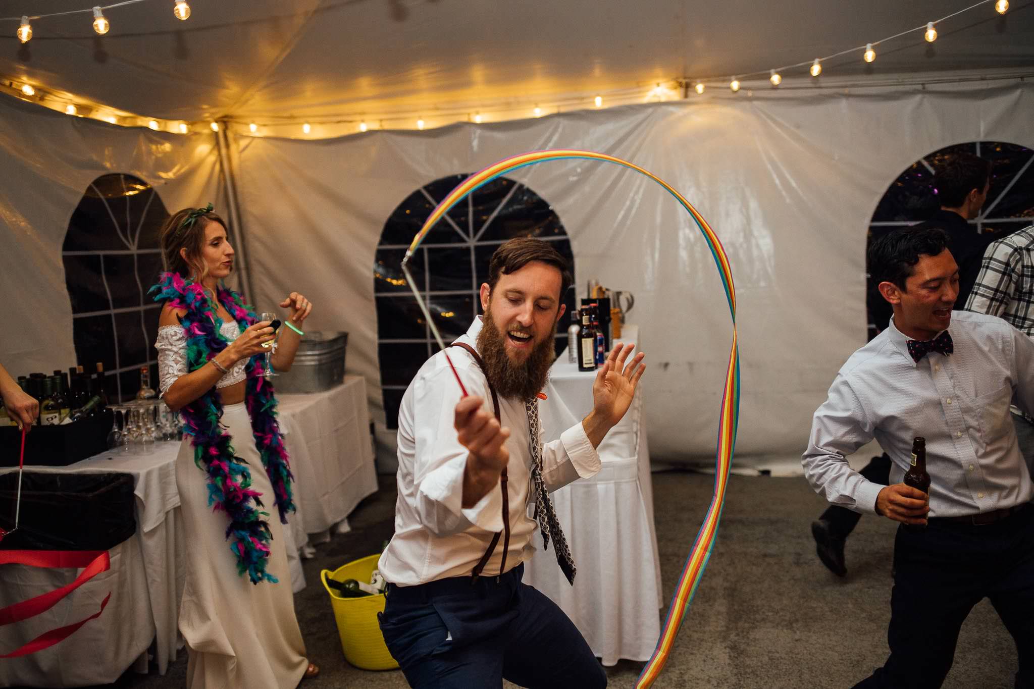 Guest dances with streamer at wedding reception Colorado Destination Wedding Photographer