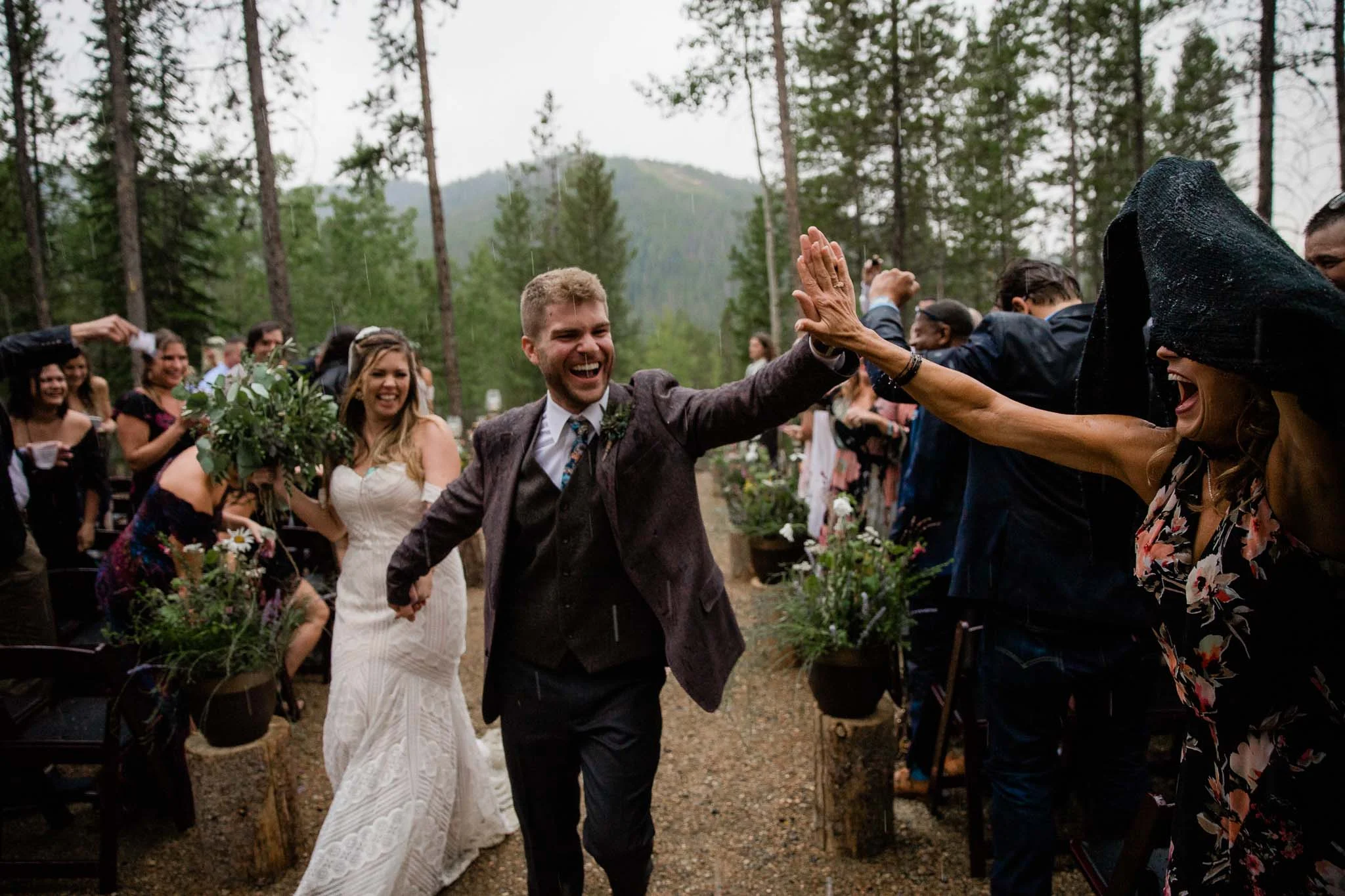 Groom high fives guest rainy Colorado Mountain wedding ceremony Winter Park