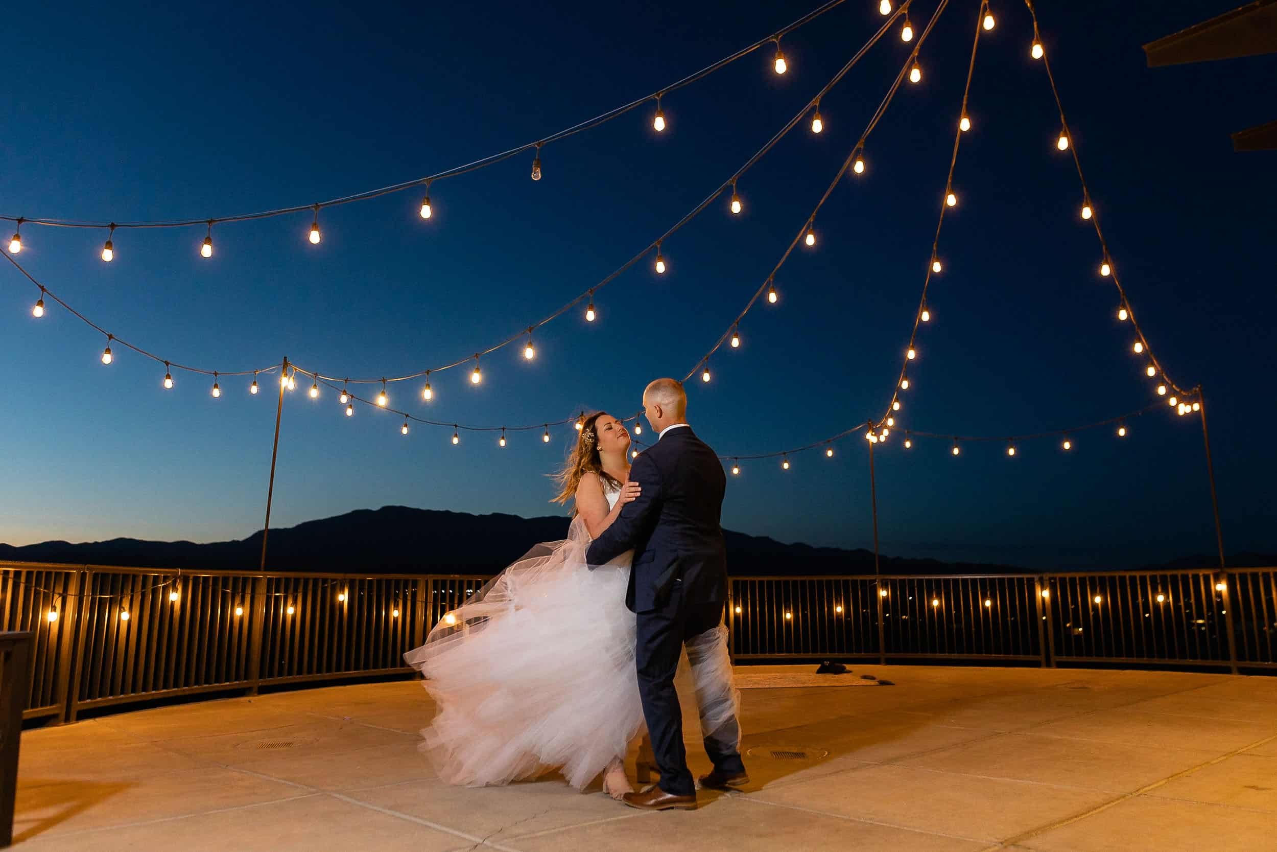 Bride and groom share first dance under string lights and the night sky at their Destination Wedding in Utah