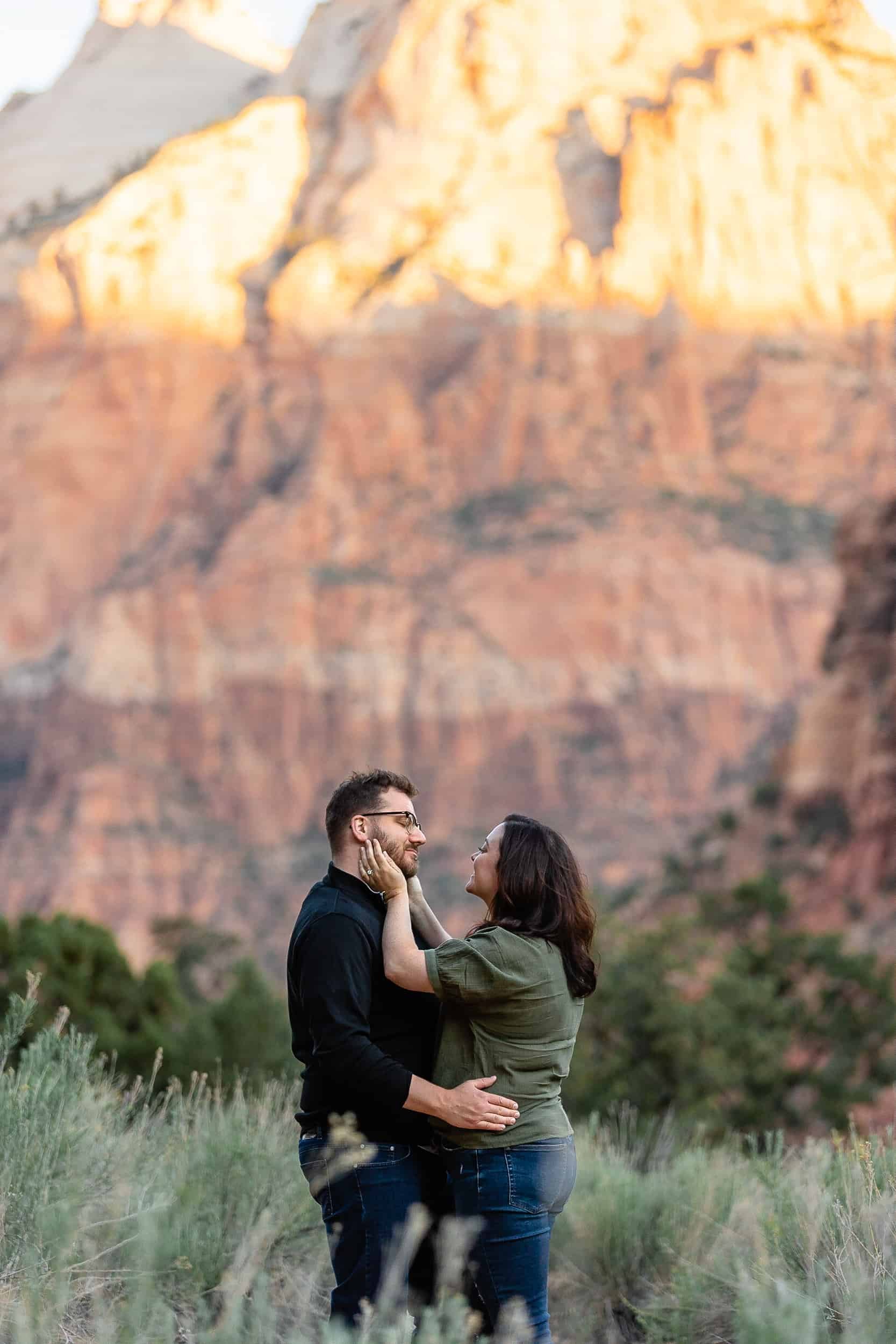 Plus sized couple hold each other during their outdoor engagement photos in Zion National Park