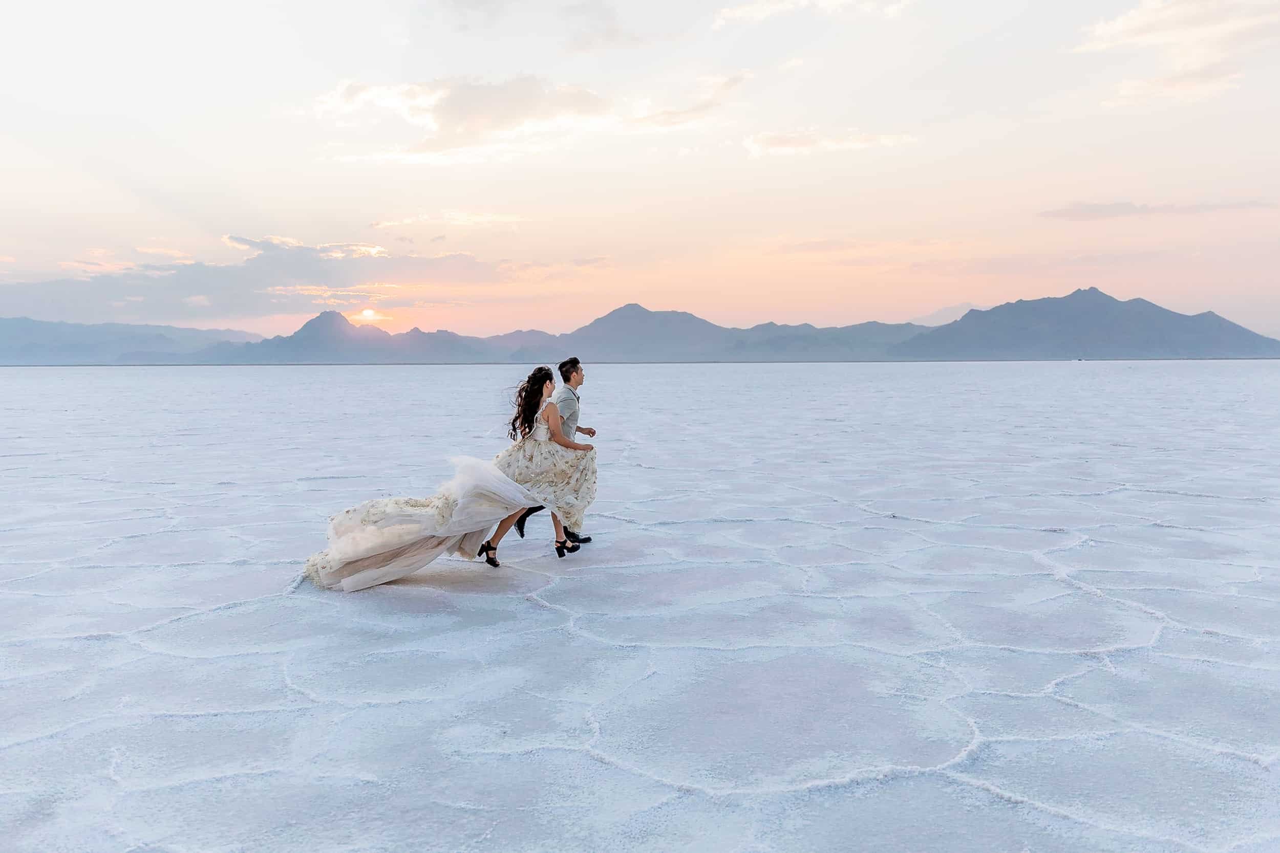 Couple run together along the Bonneville Salt Flats during their anniversary photo shoot in Utah