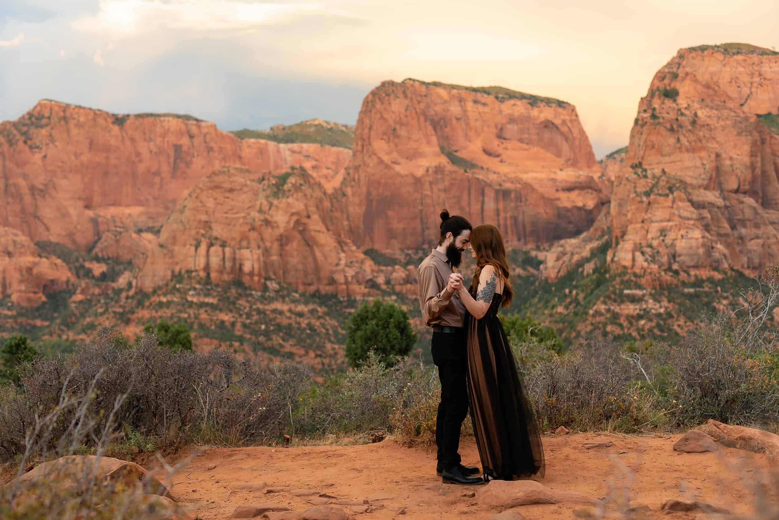 Couple dance in front of red rock cliffs during their anniversary photoshoot in Southern Utah