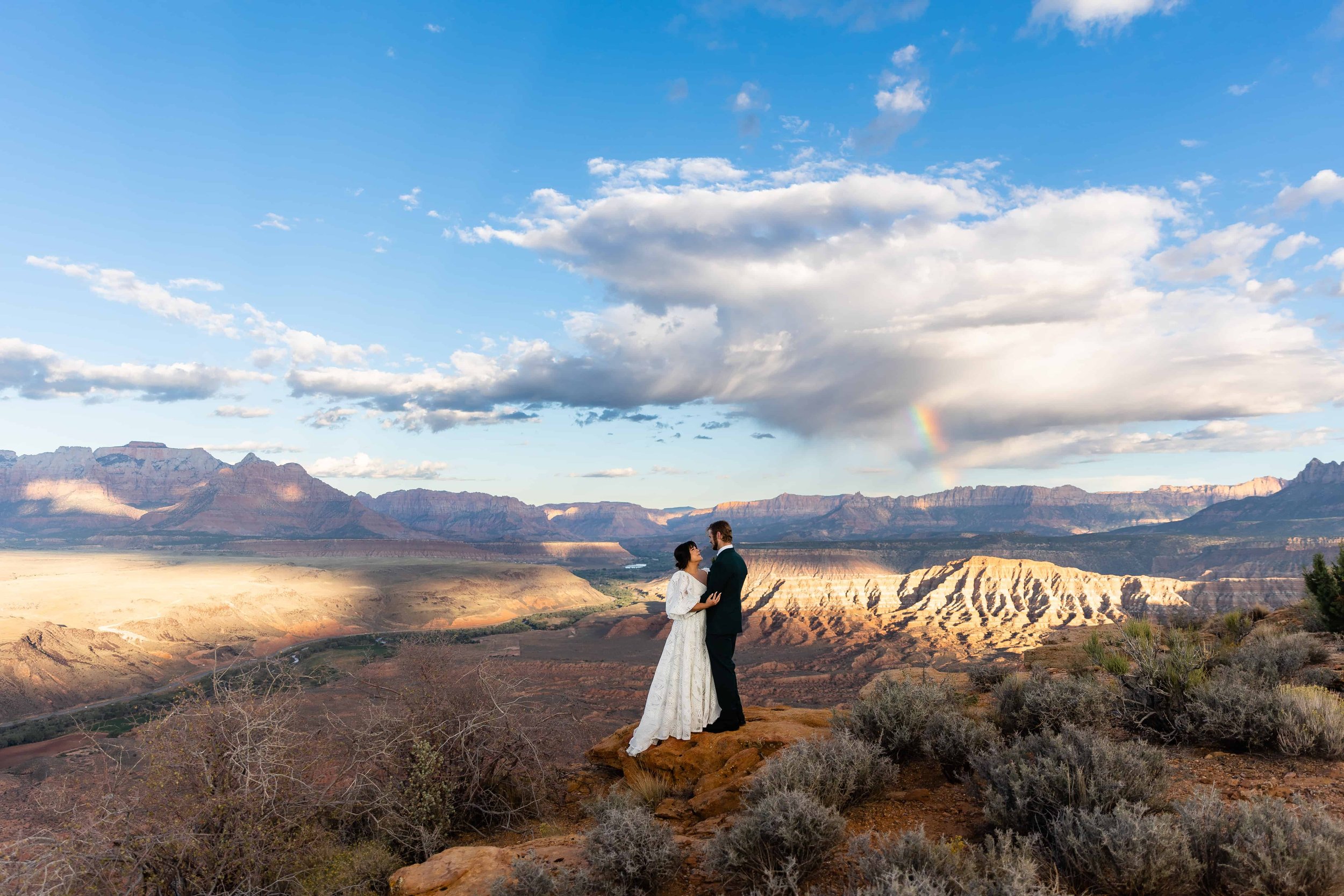 Bride and groom stand with a big view of Zion National Park during their helicopter wedding in Utah