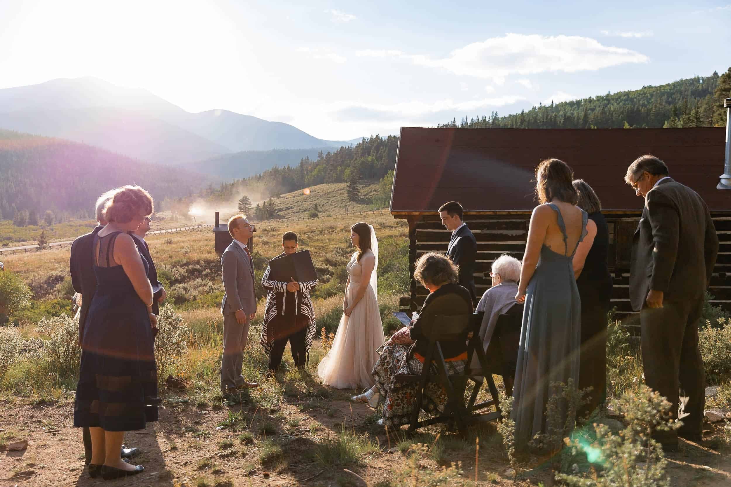 Couple close their eyes during their elopement ceremony in Colorado with their family around them