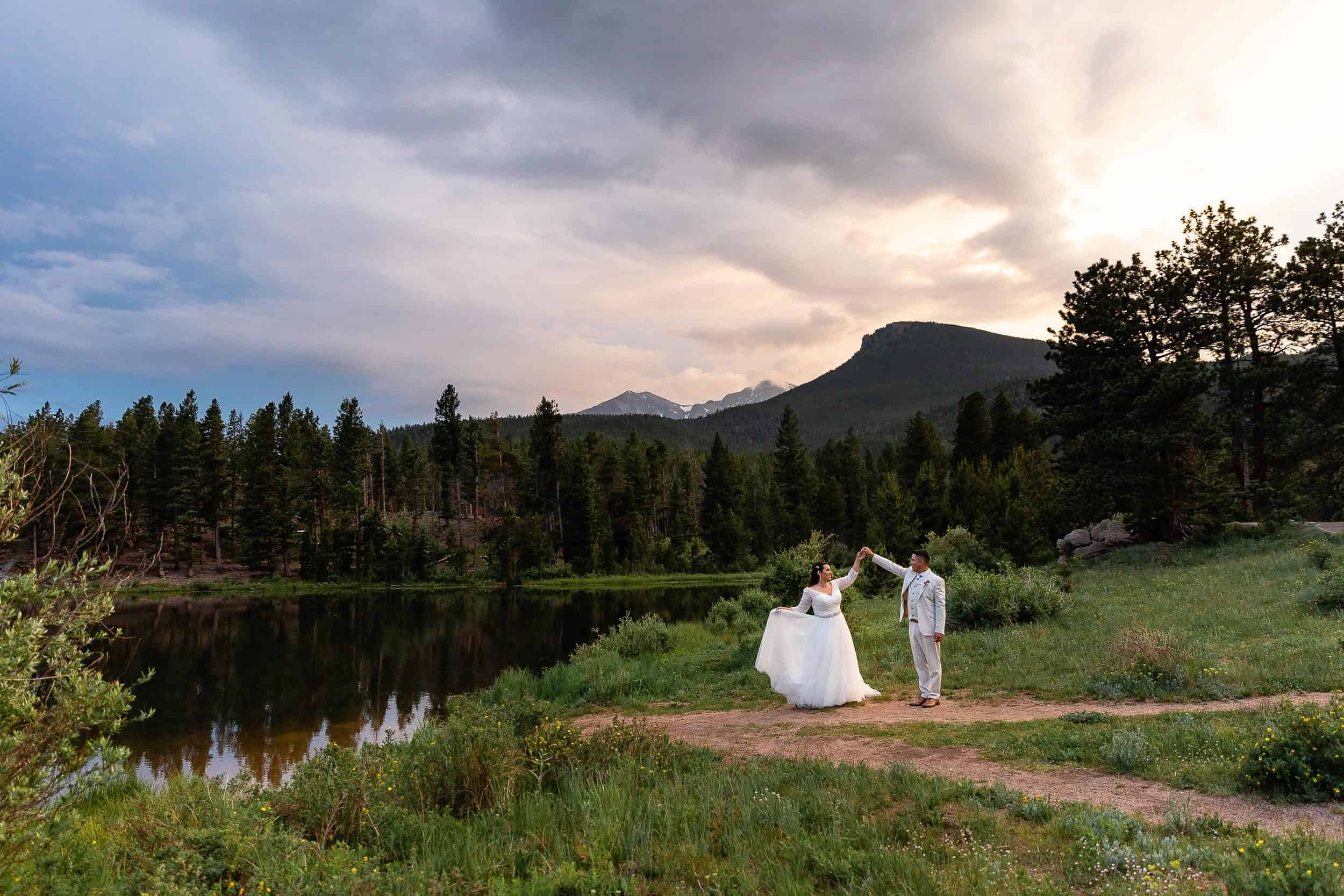 Couple dance next to an alpine lake during their elopement in Colorado