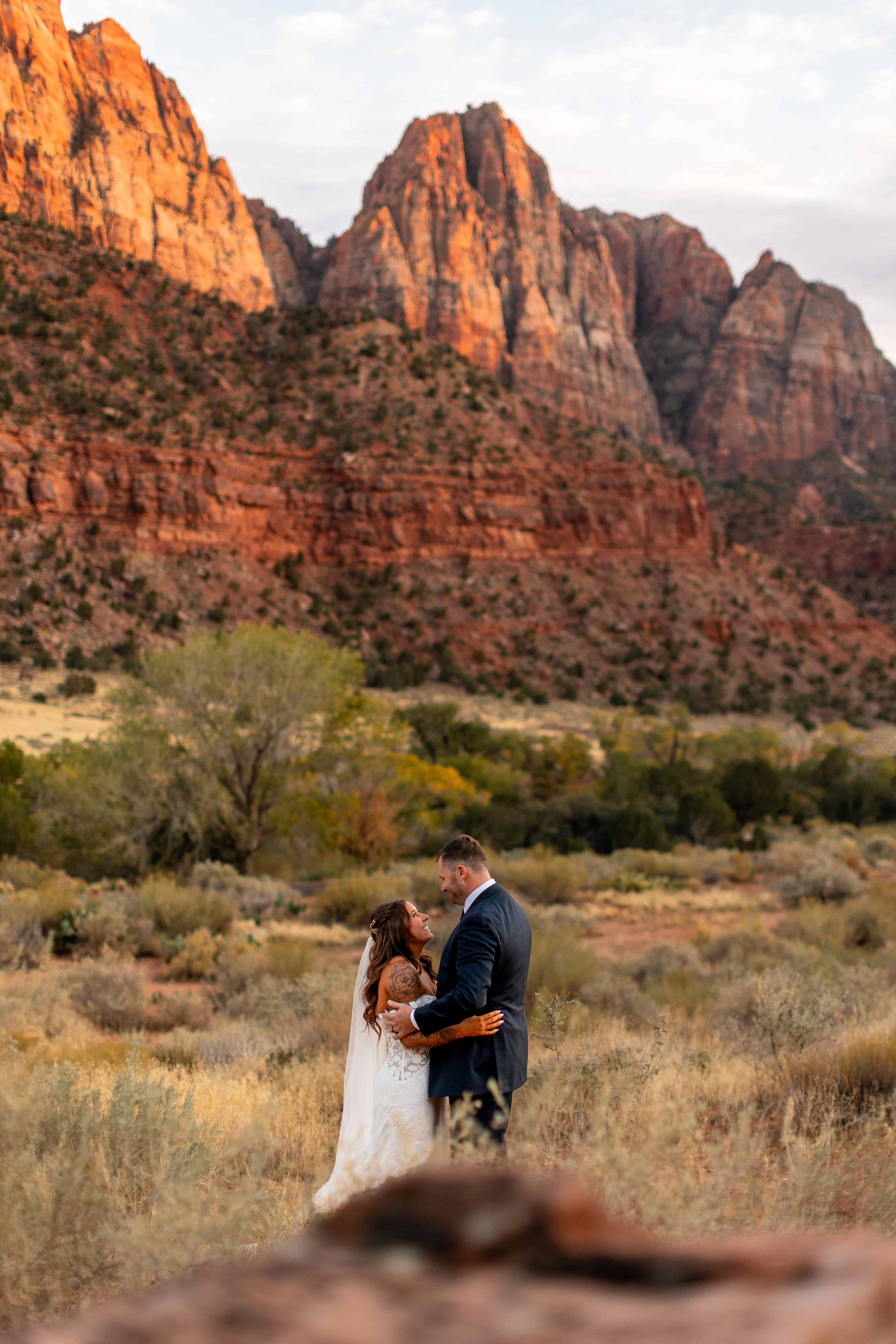 bride and groom pose together in zion national park fall