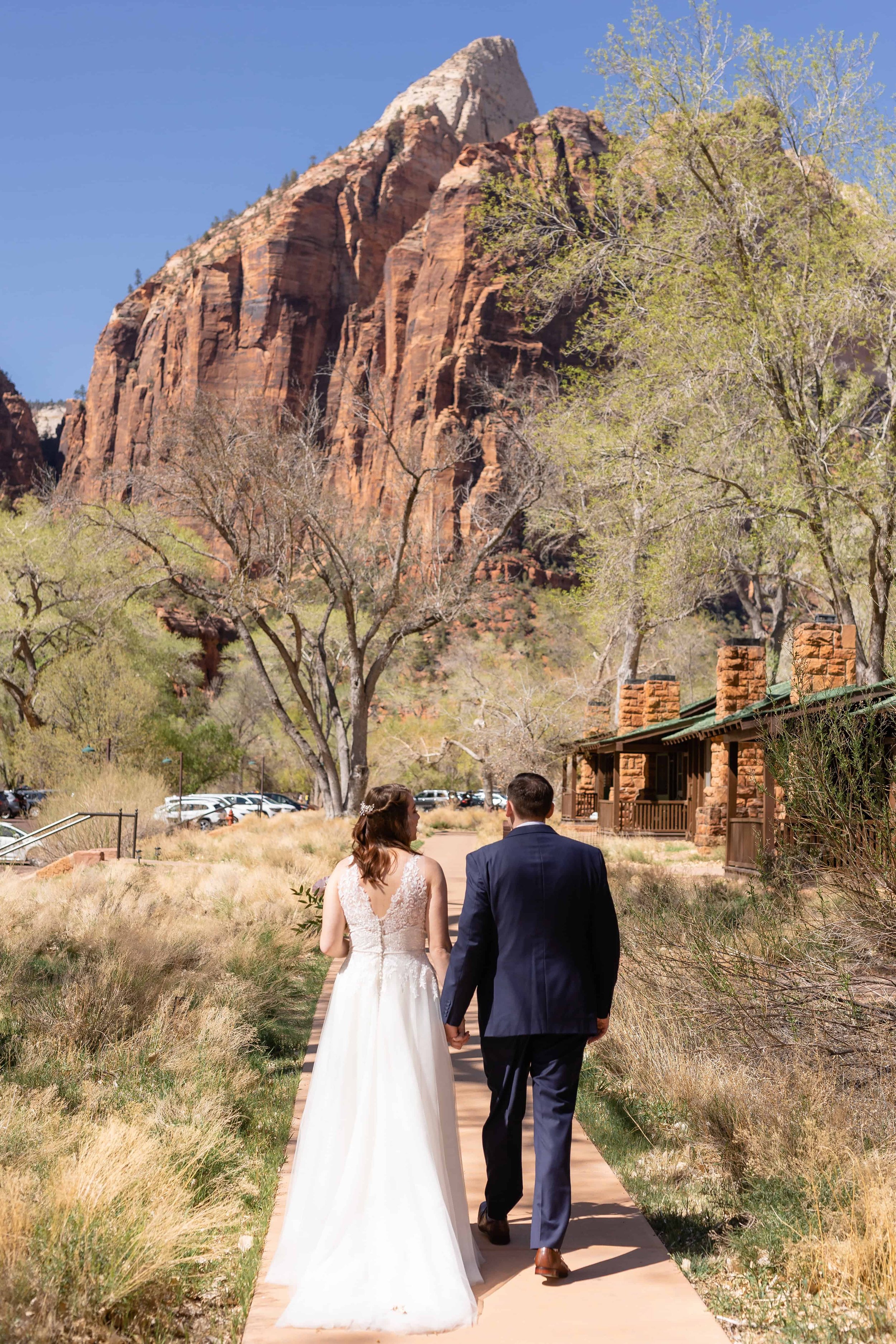 bride and groom walk together in zion national park