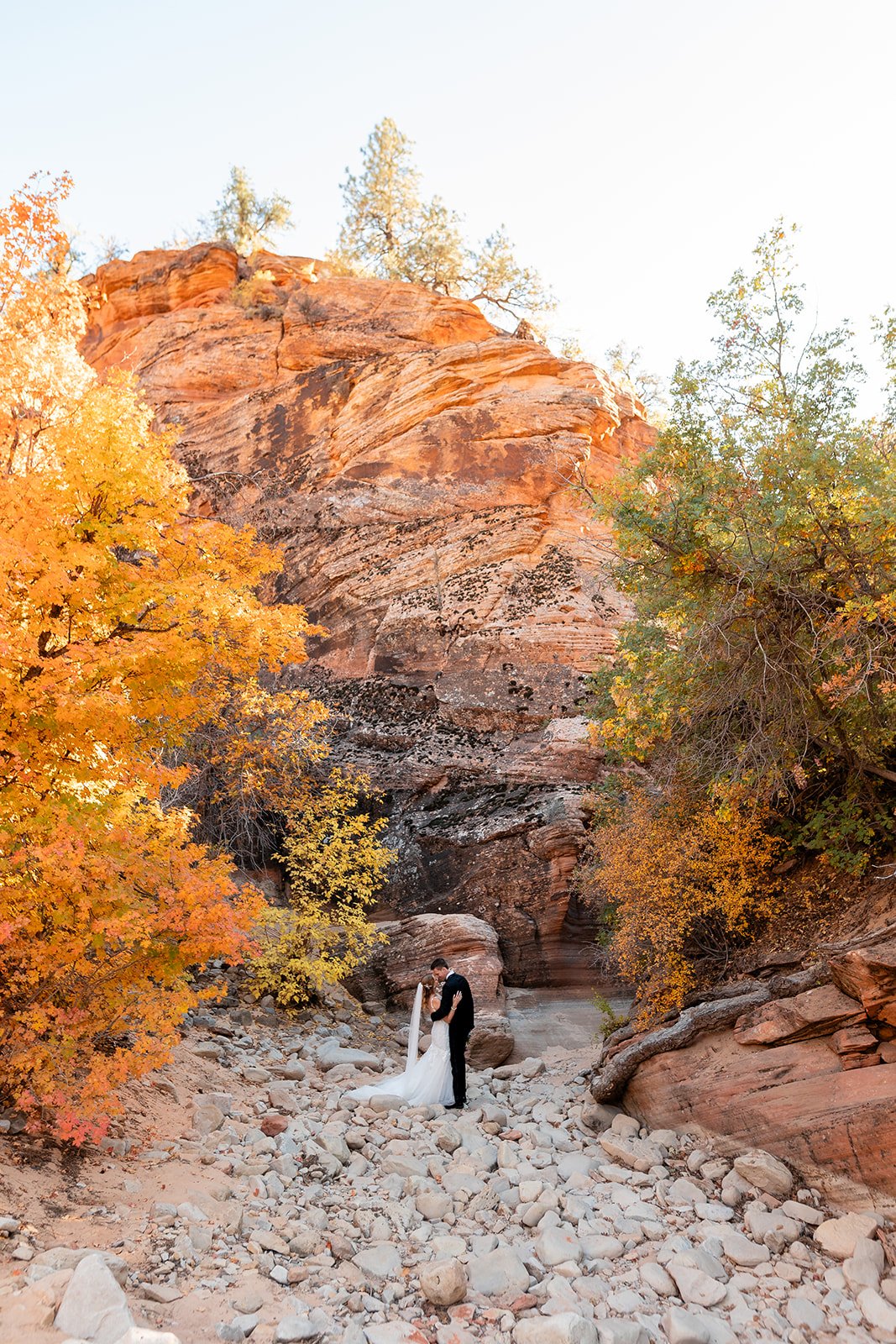 bride and groom pose in zion slot canyon during fall elopement