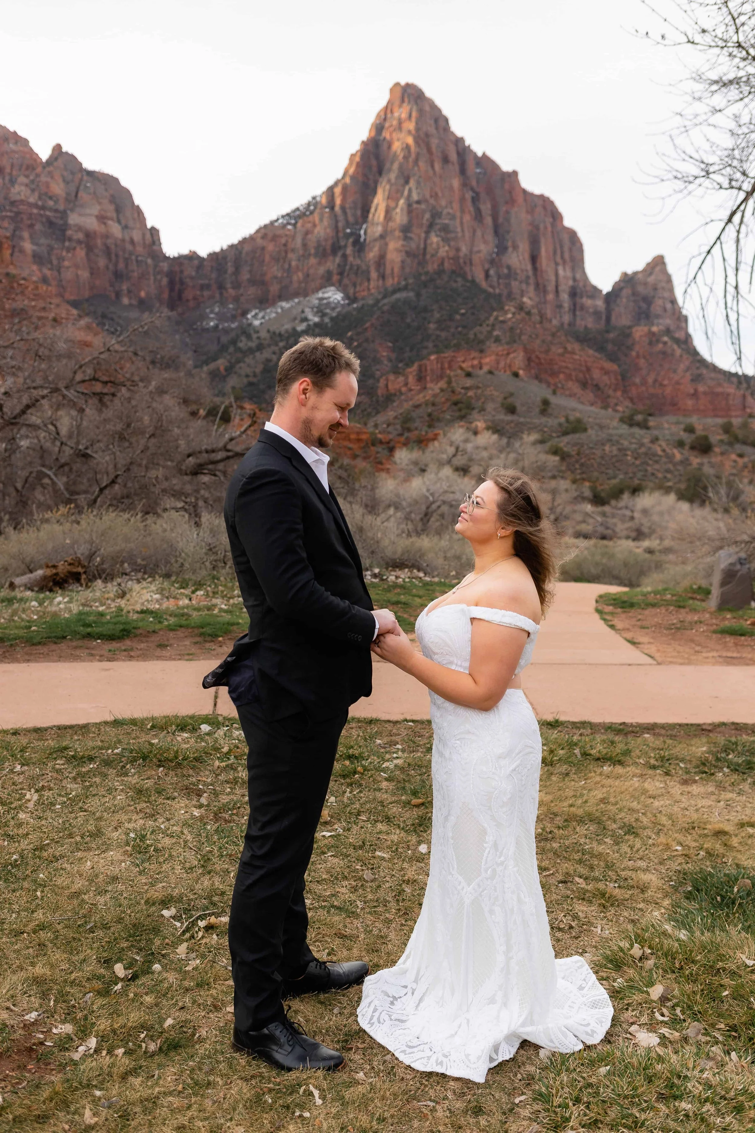 Bride and groom hold hands at south campground amphitheater